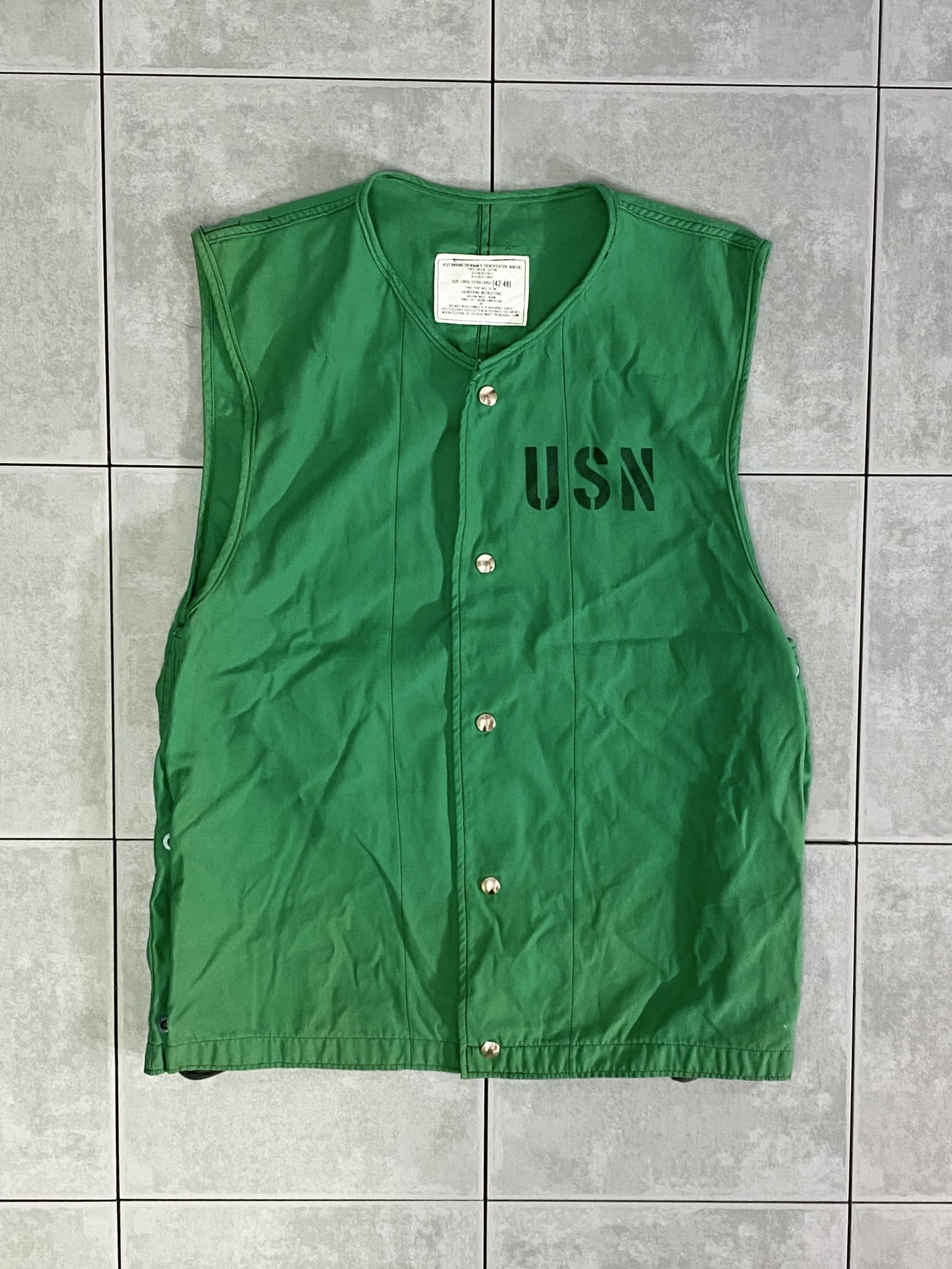 米軍放出品

80s U.S.NAVY GROUND CREWMANS VEST

カラー；グリーン

サイズ：L/XL
着丈：約68cm　身幅：約55cm　肩幅：約44cm　

素材：コットン

U.S.NAVYののグランドクルーベスト。

84年のデッドストックで、ステンシル入りは珍しいです。

着陸装置電気技師、航空管制官、整備士などが着用しています。

生地は薄手のコットン地で、視認性が高く識別も容易な
明るいグリーンカラー。

両サイドのハトメに通されたドローコードで身幅の調整が可能です。

アウトドアやタウンユース、
コーディネートのアクセントにもオススメのアイテムです。

※ハトメの腐食により紐が汚れている箇所がございます。

※米軍放出品の為、画像の程度とは若干異なる場合がございますので予めご了承下さい。
(キズ、へこみ、汚れ、穴あき、ほつれ、文字書入れ(名前、ナンバー)など
