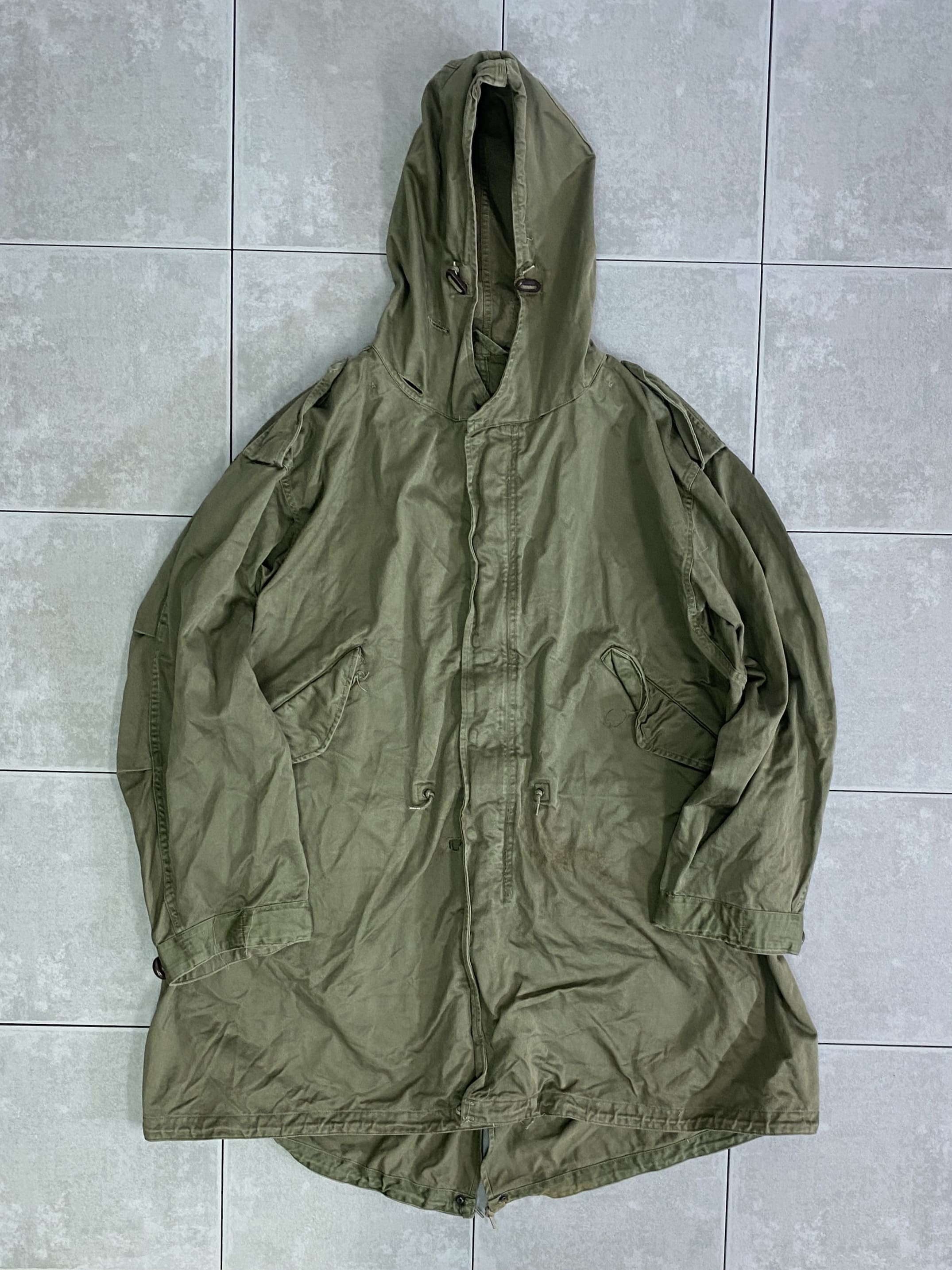 米軍放出品 実物

US PARKA SHELL M-51 

カラー：OD

サイズ：L
着丈：約102cm　身幅：約73cm　肩幅：約61cm　袖丈：約62cm

素材：厚手のコットンサテン

TALON ZIP

PATT DATE MARCH  ??  1951

一般的にモッズコート、モッズパーカ、フィッシュテールなどと呼ばれるM-51。

ヴィンテージ市場で状態の良いものを見つけることが困難な
希少性の高いモデルです。

フード一体型のデザインや肩に配されたエポレットのデザインが特徴。

USEDのコンディションで、汚れなども見られますが
まだまだ楽しんで着用できる一枚。

現在に至るまで、半世紀以上に渡って愛され続ける
ミリタリージャケットの名作です。

※フロント右側、ウエストドローコード付近
約2cm程の穴あきがございます。

※画像の程度とは若干異なる場合がございますので予めご了承下さい。
(キズ、へこみ、汚れ、穴あき、ほつれ、文字書入れ(名前、ナンバー)など
