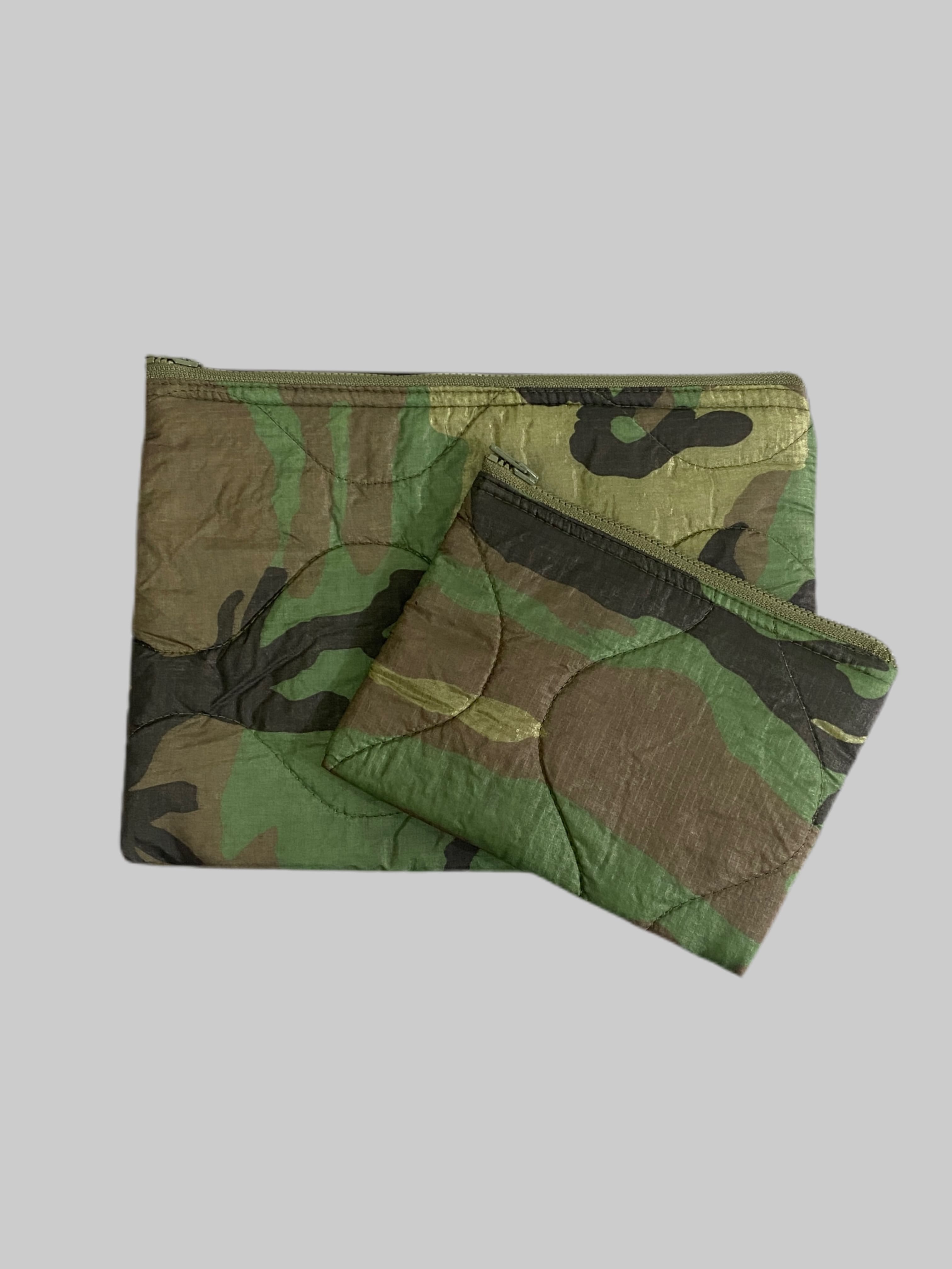 ポーチ

米軍実物 PONCHO LINER REMAKE POUCH リメイクポーチ

カラー：WOODLAND

サイズ：小：約15×20cm　大：約22×30cm

アメリカ軍で使用されていたポンチョライナーをリメイク致しました。

サイズは2種類ございます。

小サイズは、コンパクトなサイズ感で持ち運びに便利。
化粧品や、充電器など細々したもの用に。

大サイズは、クラッチバッグほどのサイズ感で、
タブレットやI Padなどのケース用としてもお使いいただけます。

両サイズとも、普段使いとしてかなり使いやすいアイテムです。

※実物新品の生地を使用しておりますが、防水性は不明です。

※商品画像とジッパーの色味が異なる場合がございます。

※画像の程度とは若干異なる場合がございますので予めご了承下さい。
(キズ、へこみ、汚れ、穴あき、ほつれ、文字書入れ(名前、ナンバー)など
