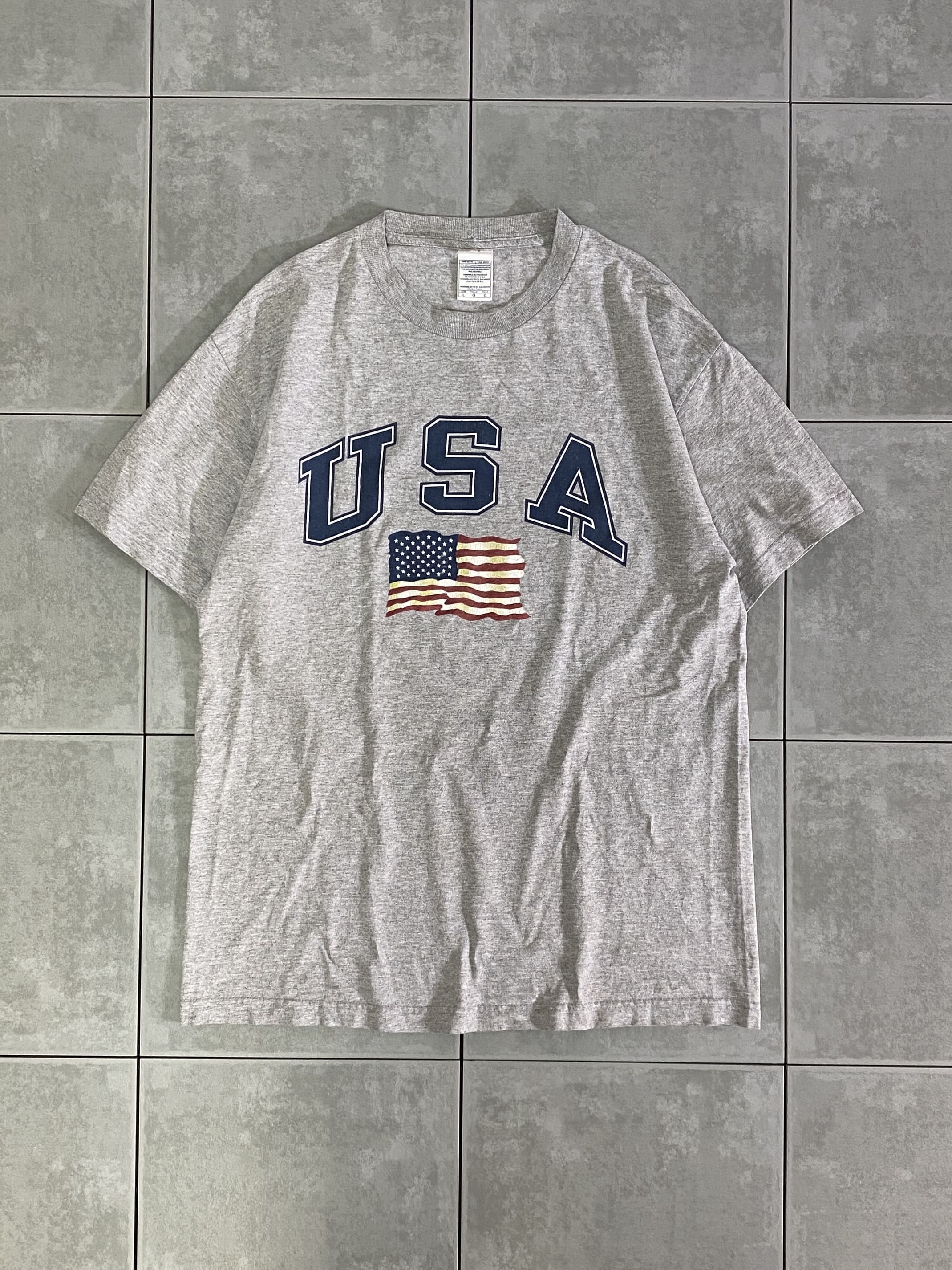 ALSTYLE

【ALSTYLE】USA S/S TEE

カラー：グレー

サイズ：L
着丈：約72cm　身幅：約53cm　肩幅：約52cm　袖丈：約21cm

素材：コットン90％　ポリエステル10％

USAプリントTシャツ。

至ってシンプルなデザインで
男女問わずお使いいただけるアイテムです。

女性は少し大きめにはなりますが
タックインなどで着用するのもオススメです。

※左肩付近、小さな穴あきがございます。

※画像の程度とは若干異なる場合がございますので予めご了承下さい。
(キズ、へこみ、汚れ、穴あき、ほつれ、文字書入れ(名前、ナンバー)など


