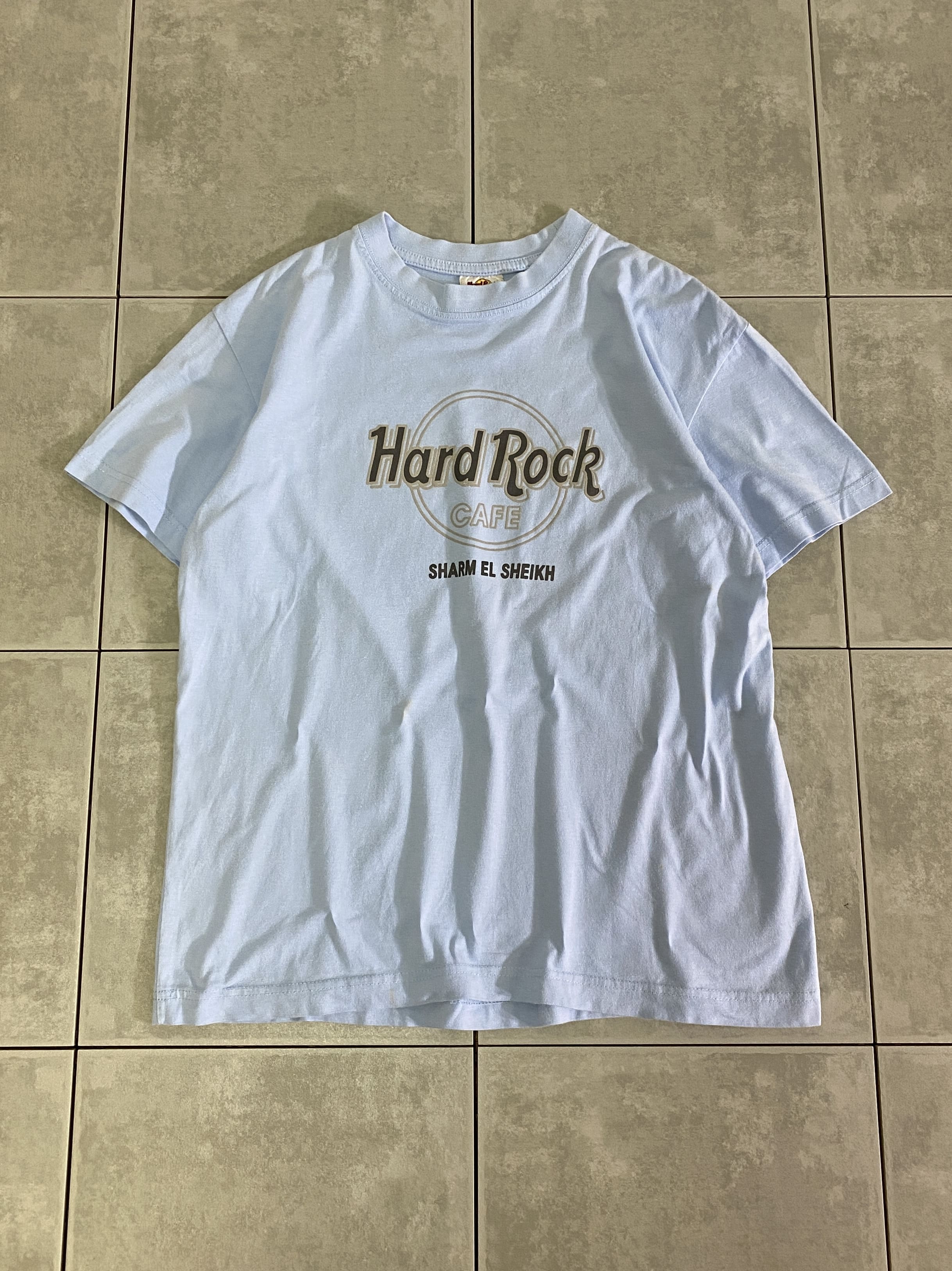 Hard Rock CAFE

【Hard Rock CAFE】S/S TEE SHARM EL SHEIKH

カラー：ライトブルー

サイズ：S
着丈：約60cm　身幅：約52cm　肩幅：約47cm　袖丈：約18cm

素材：コットン100％

Hard Rock CAFE のプリントTシャツ。

フロントに人気のHard Rock CAFEのロゴプリント。

プリントの色味は薄めですが、ライトブルーのボディーが
爽やかで夏にピッタリのアイテム。

男女問わずお使いいただけます。

※フロント中央付近、小さい汚れがございます。

※画像の程度とは若干異なる場合がございますので予めご了承下さい。
(キズ、へこみ、汚れ、穴あき、ほつれ、文字書入れ(名前、ナンバー)など