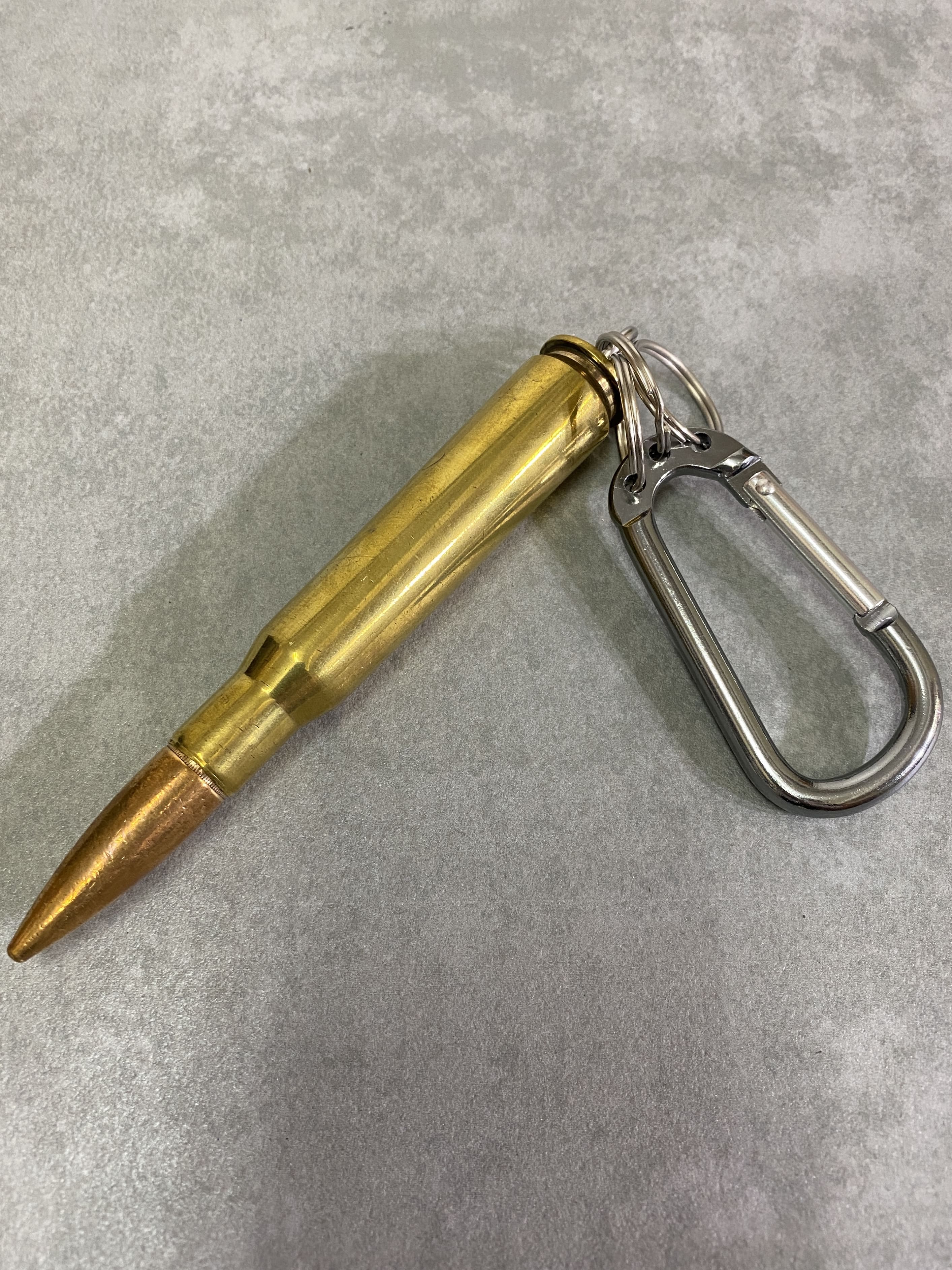 ダミーカート

50bmg キーホルダー

カラー：ゴールド

サイズ：12.7mm

ダミーカートキーホルダーです。

米軍が訓練等で使用した実物使用済み薬莢に実物弾頭を取り付けています。

重量感もあり、リアル感が楽しめるアイテムです。

薬莢は使用済みで火薬は一切入っていない安全品です。

コレクションやディスプレイ等にいかがでしょうか。

※画像の程度とは若干異なる場合がございますので予めご了承下さい。
(キズ、へこみ、汚れ、穴あき、ほつれ、文字書入れ(名前、ナンバー)など
