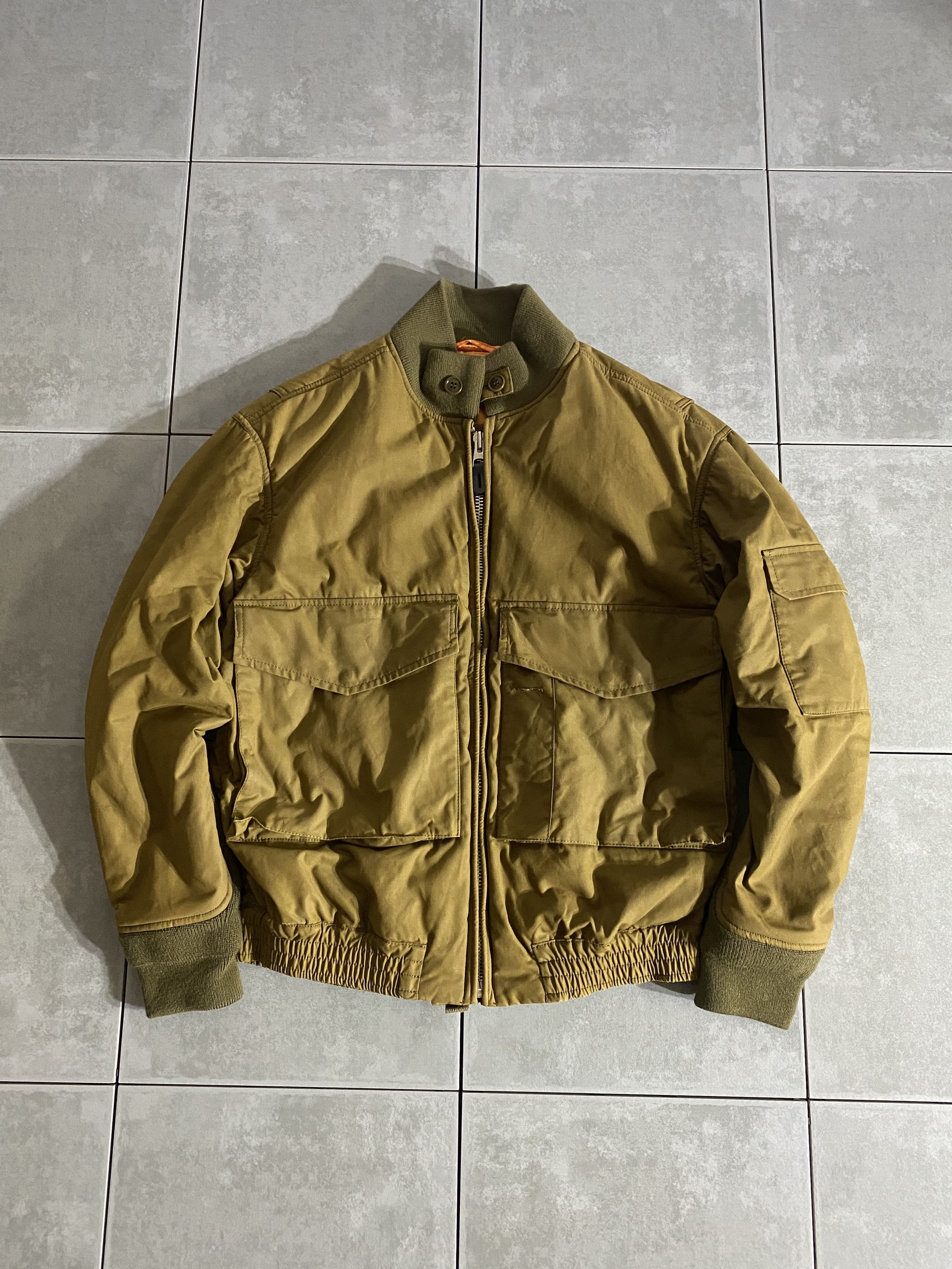 AMERICAN RAG CIE

【AMERICAN RAG CIE】G-8（WEP）JACKET

カラー：OLIVE

サイズ：不明
着丈：約61cm　身幅：約52cm　肩幅：約49cm　袖丈：約58cm

素材：オイルドコットン

アメリカンラグシーオリジナル、イギリスの老舗生地メーカー
British Millerainを使用したミリタリーブルゾン。

海軍のMA-1といわれるJ-WFS G-8。

アメリカ海軍航空局によって開発され、
4回のマイナーモデルチェンジを経て
1970年代中期まで支給されたフライトジャケットです。

特徴的なビッグフラップポケット、袖口の可動、
後期型の特徴ともいえるV字型に装着された手首のニットカフス、
アクションプリーツなど、実際のミリタリーヴィンテージの
ディテールを忠実に再現。

機能面では、身頃フラップポケットの側面にスラッシュポケットを付け
街着としても使いやすディテールになっています。

※画像の程度とは若干異なる場合がございますので予めご了承下さい。
(キズ、へこみ、汚れ、穴あき、ほつれ、文字書入れ(名前、ナンバー)など
