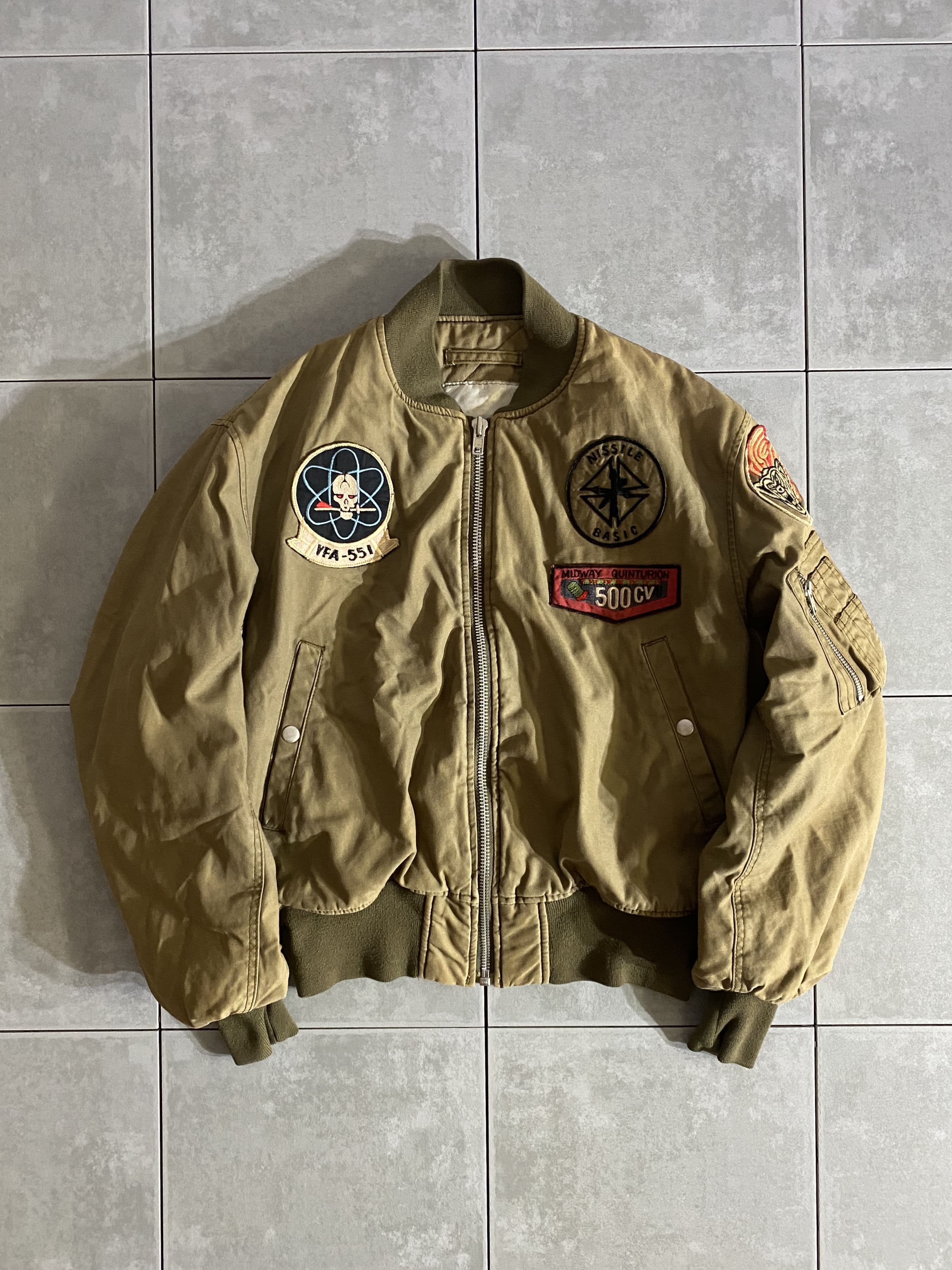 民間用

MA-1 FLIGHT JACKET

カラー：TAN

サイズ：不明
着丈：約60cm　身幅：約61cm　肩幅：約51cm　袖丈：約63cm

素材：コットン

ブランド不明の民間用MA-1、バッチ付き。

王道のMA-1ではなく、
コットン素材にTANカラーといった珍しいアイテム。

ボタン付きの斜めポケット、左腕にシガレットポケットなど、
シンプルなディテール。

中綿入りで重厚感があり、色味、パッチとも相まって
男らしさ全開のアイテムです。

比較的きれいなコンディションで、リブなどのダメージもなく
ユニセックスでお使いいただけます。

※画像の程度とは若干異なる場合がございますので予めご了承下さい。
(キズ、へこみ、汚れ、穴あき、ほつれ、文字書入れ(名前、ナンバー)など