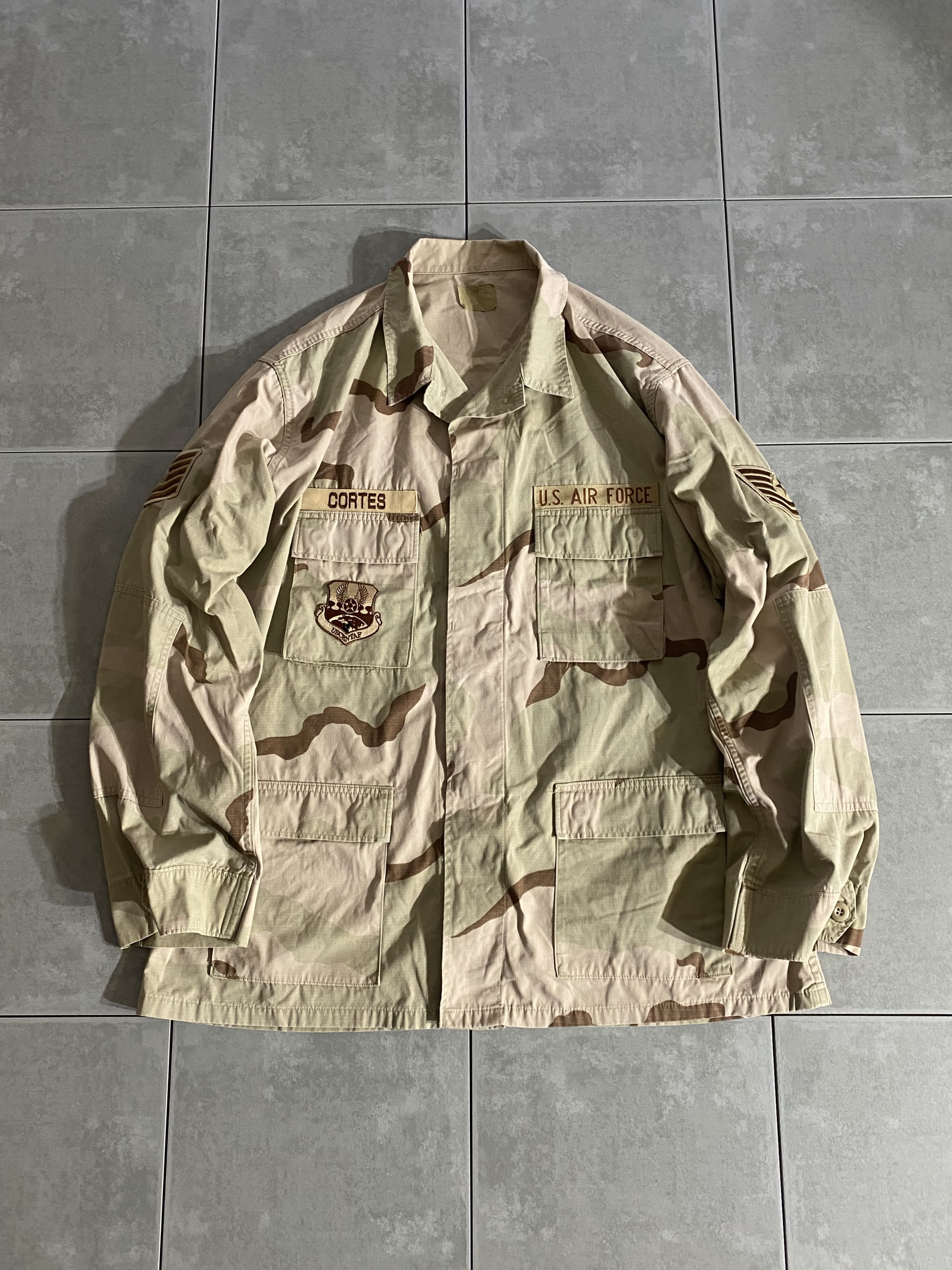 米軍放出品

3C Desert Camo DCU Jacket

カラー：3C

サイズ：XL-L
着丈：約82cm　身幅：約70cm　肩幅：約53cm　袖丈：約67cm

素材：コットン　ナイロン

リップストップ

1990年代初頭より全軍に採用されたDCUジャケット。

フロント4ポケットのBDUジャケットと同様のデザインで、
DCUいう3カラーで構成された迷彩柄。

砂漠地帯を対象として作成され、より有効性の高い
迷彩パターンとして採用されております。

ファッション性の高いデザインでミリタリーの
定番とも言えるジャケットです。

薄手で羽織りやすく、様々なスタイリングに合わせて
楽しんでいただけるアイテムです。

※タグの印字全て消えております。

※画像の程度とは若干異なる場合がございますので予めご了承下さい。
(キズ、へこみ、汚れ、穴あき、ほつれ、文字書入れ(名前、ナンバー)など
