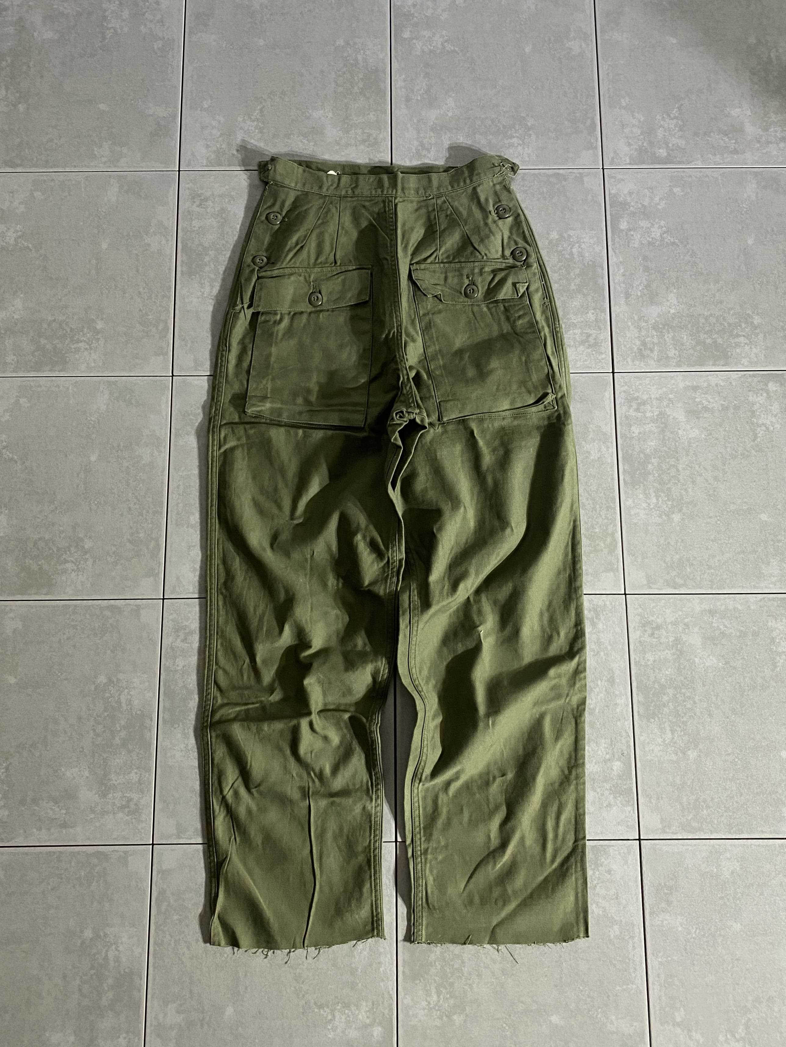 米軍放出品

60s SLACKS WOMENS COTTON SATEEN OG-107

カラー：OD

サイズ：14
ウエスト：約68cm　股下：約70cm　ワタリ：約32cm　総丈：約102cm

素材：コットン

女性用のユーティリティーパンツ。

前後で逆のようなデザインになっております。

ベルトループ、フロントのジッパーやボタンが無く
サイドのボタンで着脱するタイプです。

バックポケットは無く、フロントのポケットのみ。

ほとんど見ることのない珍しいパンツです。

※裾カットされています。

※画像の程度とは若干異なる場合がございますので予めご了承下さい。
(キズ、へこみ、汚れ、穴あき、ほつれ、文字書入れ(名前、ナンバー)など