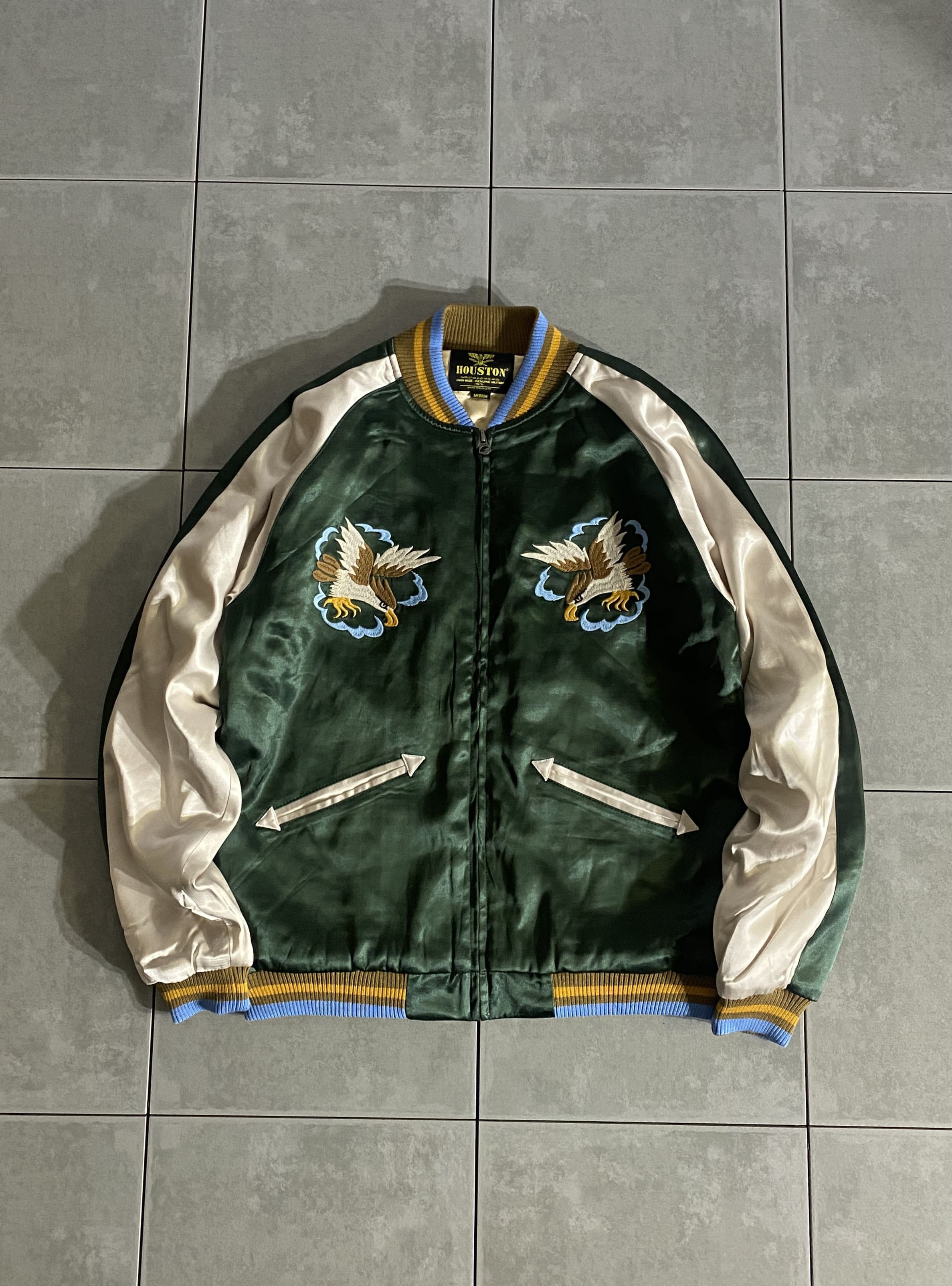 HOUSTON

【HOUSTON】SOUVENIR JACKET(MARIA)

カラー：GREEN

サイズ：M / L / XL
M 着丈:約63cm 身幅:約54cm 裄丈:約85cm 
L 着丈:約65cm 身幅:約57cm 裄丈:約86cm 
XL 着丈:約67cm 身幅:約60cm 裄丈:約87cm 

素材：レーヨン / アクリル / ポリエステル

肌触りもよく、ハリもあり肉厚なレーヨンサテンを使用した
スーベニアジャケット。

ヴィンテージにもよく見られる鷹と、インパクトのあるマリア柄の
デザインを手振り風刺繍で仕上げたクラシカルな見た目に仕上げています。

裏地には表地と同じ生地を使用し、
カラーはコージャス感があるシャイニーゴールドを採用。

中綿入りで保温性にも長けているオススメアイテムです。