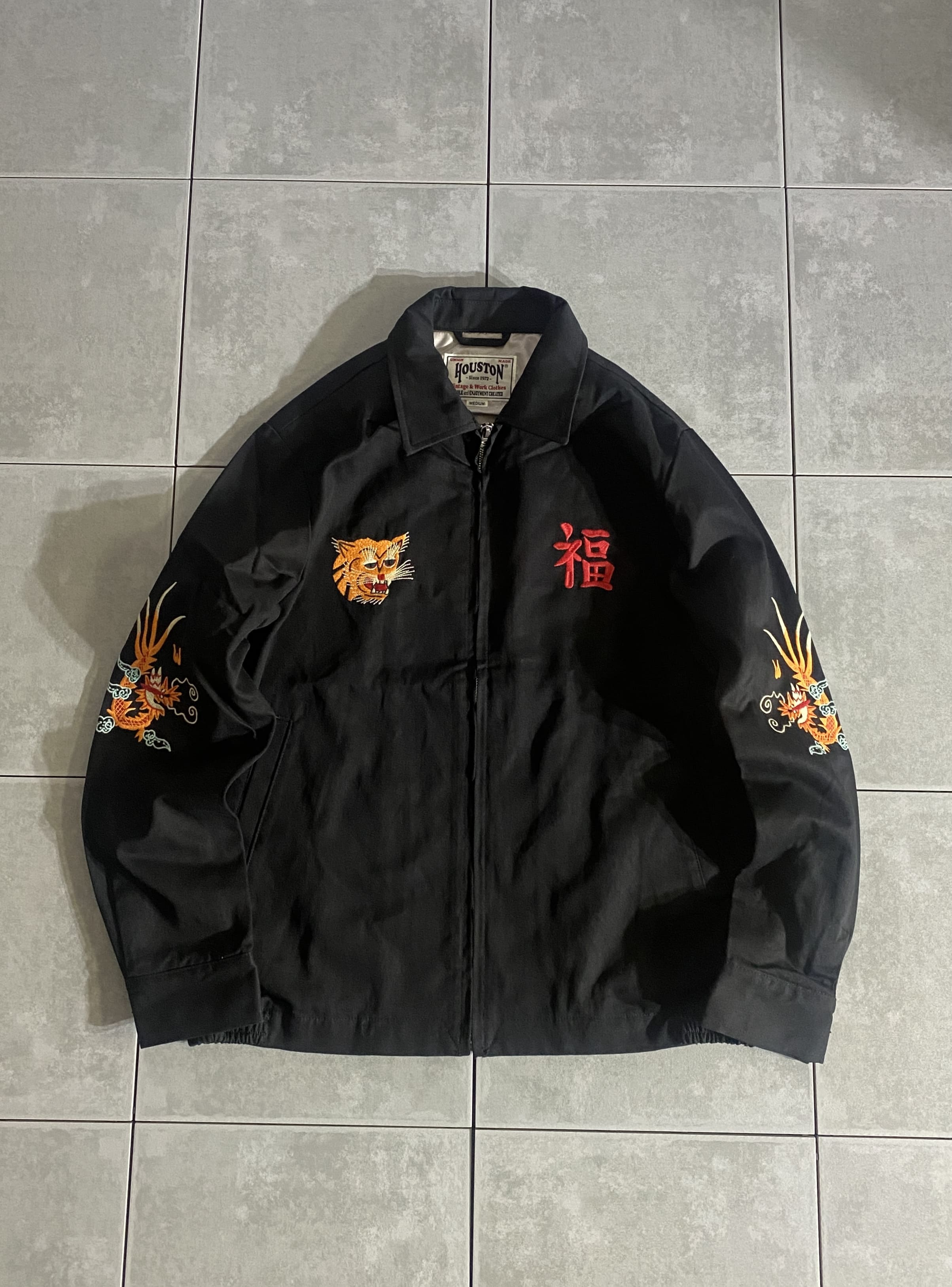 HOUSTON

【HOUSTON】VIETNAM JACKET(MAP)

カラー：BLACK

サイズ：M / L / XL
M 着丈:約68cm 身幅:約57cm 肩幅:約45cm 袖丈:約62cm
L 着丈:約70cm 身幅:約60cm 肩幅:約47cm 袖丈:約63cm
XL 着丈:約72cm 身幅:約63cm 肩幅:約49cm 袖丈:約64cm

素材：コットン

ベトナム戦争後にアメリカ軍兵士が使用したパラシュートや
寝袋などをジャケットに作り直し、お土産として持ち帰った物が所以の
ベトナムジャケット、通称「ベトジャン」。

生地にはコットンを100％使用し、柔らかく、肌触りの良い仕上がりに。

胸に「福」と「虎」の顔を刺?し、背面にはベトナムの地図、
ベトナムに在留した期間である「66 67」の数字もデザイン。

チノパンやデニムなど様々なパンツと相性良く、
コーディネートの主役になる一着です。


