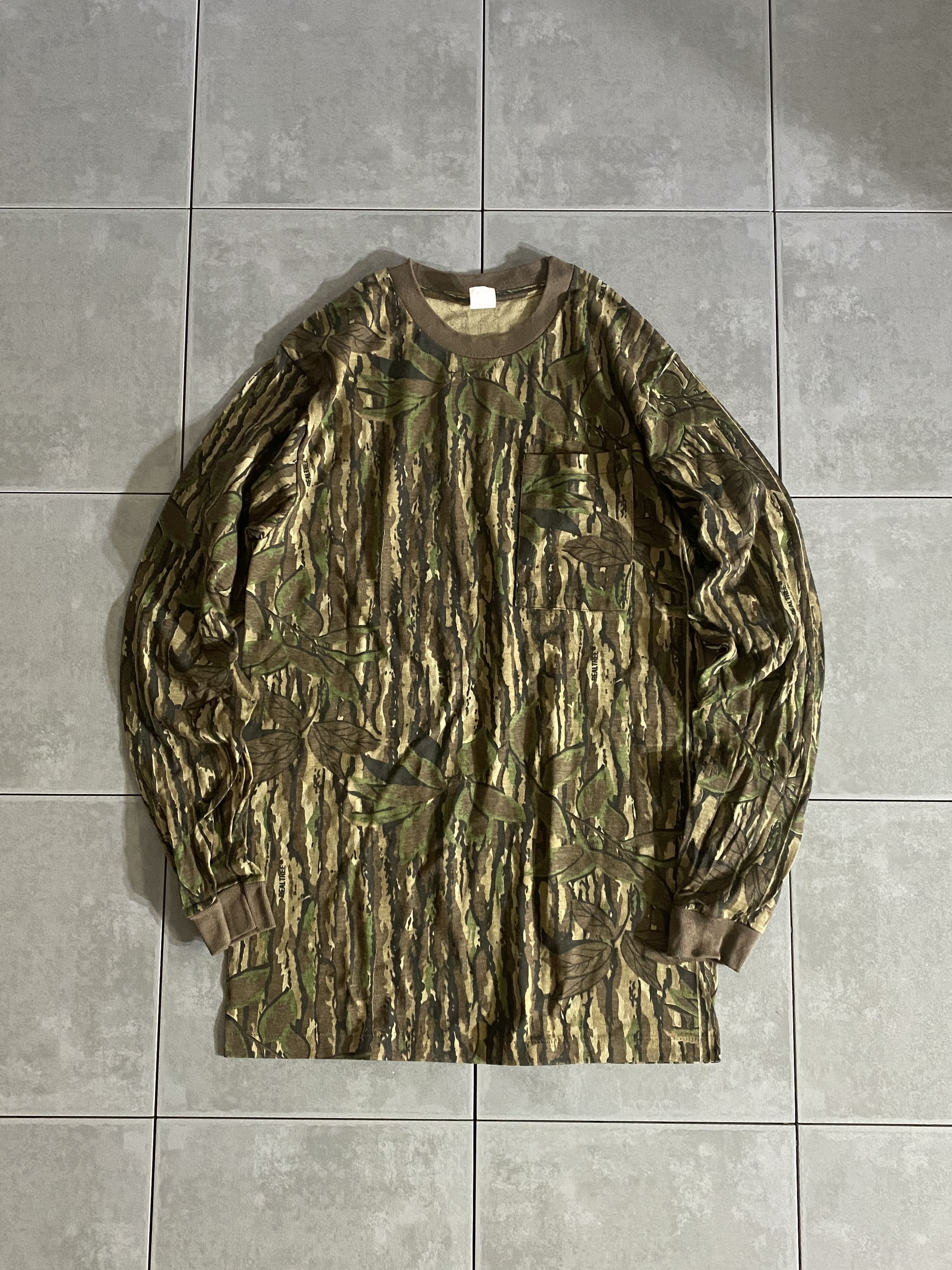 MADE IN USA

REALTREE CAMO L/S TEE

カラー：REALTREE CAMO

サイズ：S
着丈：約75cm　身幅：約47cm　肩幅：約43cm　袖丈：約65cm

素材：コットン

リアルツリーの長袖ポケットTシャツ。

アメリカ製の新品です。

ストリートファッションではいつの時代になっても
人気の高い迷彩柄ですが、その中でも人気の絶えないリアルツリー柄。

存在感抜群なので、一枚だけでもカッコよくきまりますが
インナーとしても万能なアイテムです。

※画像の程度とは若干異なる場合がございますので予めご了承下さい。
(キズ、へこみ、汚れ、穴あき、ほつれ、文字書入れ(名前、ナンバー)など