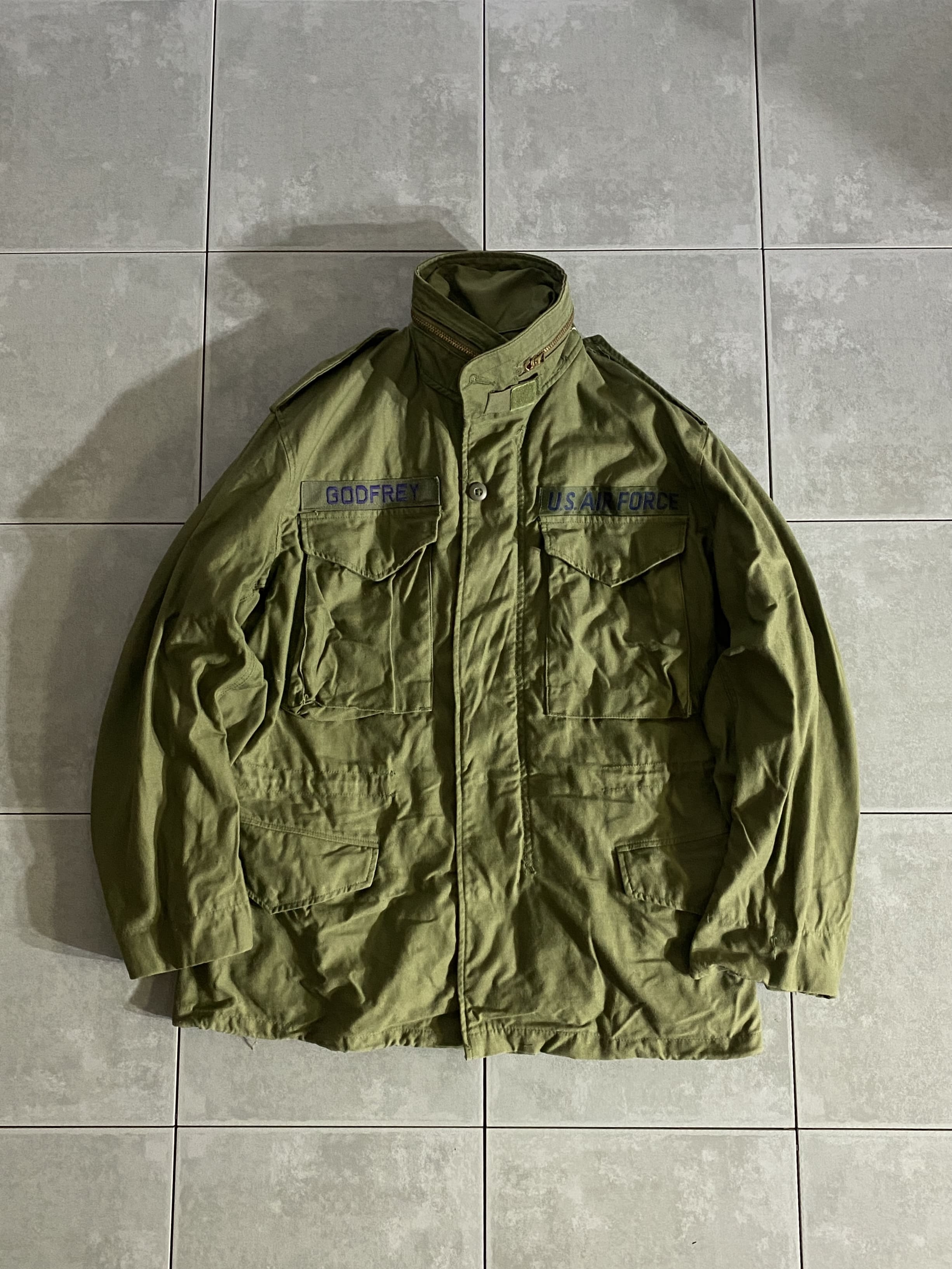 米軍放出品

70s M-65 FIELD JACKET 3rd Model

カラー：OD

サイズ：S-S
着丈：約73cm　身幅：約56cm　肩幅：約50cm　袖丈：約60cm

素材：コットン　ナイロン

GENERAL ZIP

軍が開発したミリタリーアイテムの中で最高傑作ともいえる
M-65 FIELD JACKET。

ミリタリーを語る上で外せないアイテムです。

アルミジップからブラスジップに変わった
3rd Model。

収納式フード、肩にはエポレット付きで
フロント部分はジッパーとスナップボタンで開閉できます。

目立ったダメージもないグッドコンディションです。

ODは特に放出がなく年々希少価値が上がっているので
今のうちに買っておくのがオススメです。

※画像の程度とは若干異なる場合がございますので予めご了承下さい。
(キズ、へこみ、汚れ、穴あき、ほつれ、文字書入れ(名前、ナンバー)など

