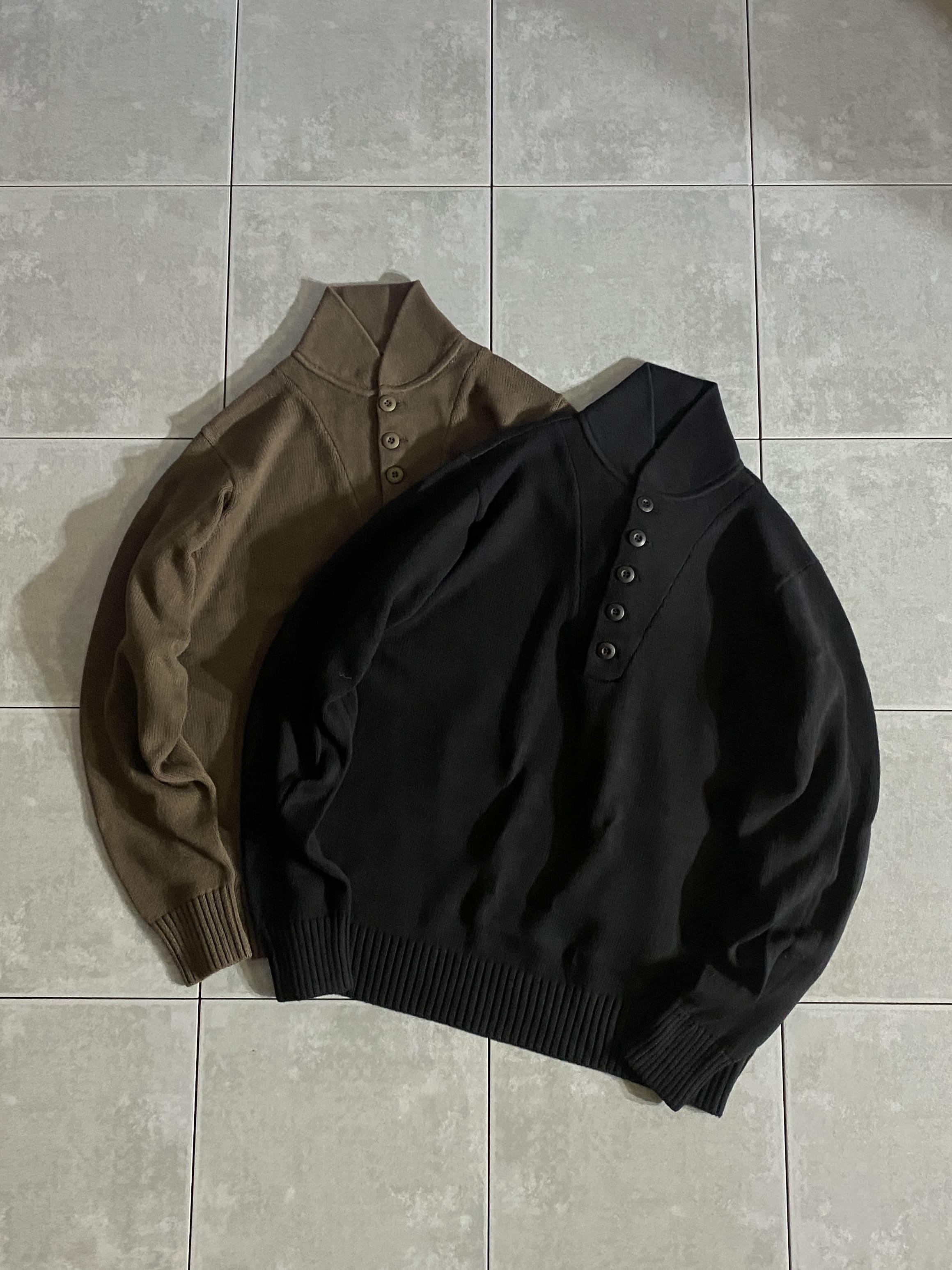 セーター

5ボタンコットンニット ヘンリーネックセーター

カラー：BLACK / BROWN

サイズ：S / M / L / XL
 S 着丈:約65cm 身幅:約51cm 肩幅:約42cm 袖丈:約62cm
 M 着丈:約68cm 身幅:約54cm 肩幅:約45cm 袖丈:約65cm
 L 着丈:約71cm 身幅:約57cm 肩幅:約48cm 袖丈:約68cm
XL 着丈:約74cm 身幅:約60cm 肩幅:約51cm 袖丈:約71cm

素材：コットン100％

ウールのニットを使用したヘンリーネックはWWIIから
ジープセーターとして防寒性を高めるインナーとして
長らく米軍で採用されています。

特徴的なデザインの5ボタンのヘンリーネックは、
ヴィンテージらしいレトロなディテールがアイコニックな一着。

一枚での着用からジャケットスタイルのインナーとしても
非常に使い勝手に優れたニットになっております。

首に沿ったスタンドカラーデザインは折り返して着るもよしで
着こなしのアレンジも楽しめます。