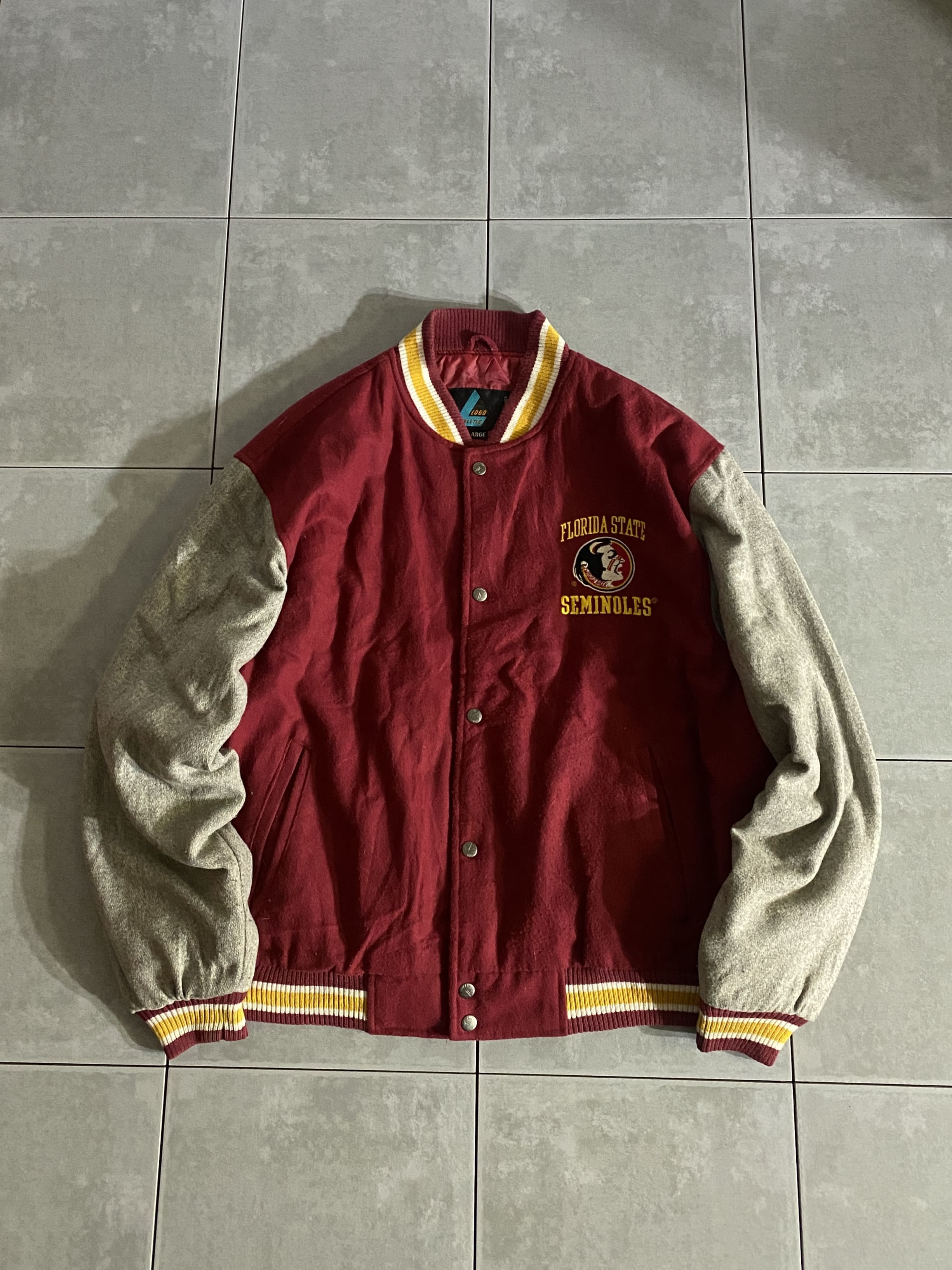 LOGO ATHLETIC

【LOGO ATHLETIC】Florida State Seminoles AWARD JACKET

カラー：バーガンディ

サイズ：XL
着丈：約67cm　身幅：約70cm　肩幅：約57cm　袖丈：約64cm

素材：ウール　アクリル　ポリエステル

フロリダ州立大学を代表する
アメリカンフットボールチームのセミノールズ。

Florida State Seminolesモデルのスタジャンです。

どのボトムスとも合わせやすい
チームカラーのバーガンディがクールな一着。

着丈も長すぎず、バランスの取れたシルエット。

サイズはXLと少し大きめなので、
オーバーサイズでの着用やストリートの方にオススメです。

※画像の程度とは若干異なる場合がございますので予めご了承下さい。
(キズ、へこみ、汚れ、穴あき、ほつれ、文字書入れ(名前、ナンバー)など

