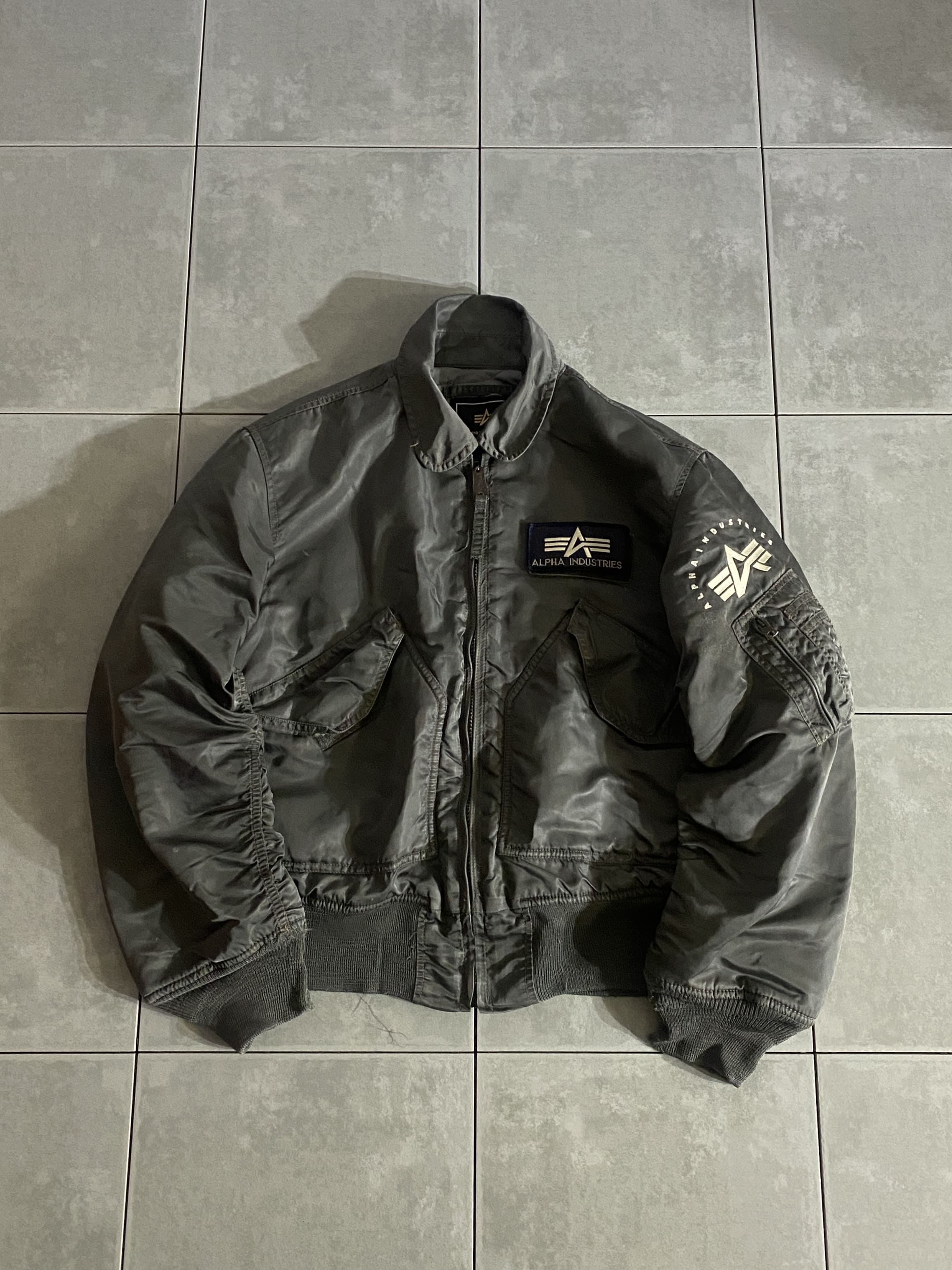 ALPHA

【ALPHA】CWU-45/P FLIGHT JACKET

カラー：SAGE

サイズ：S
着丈：約61cm　身幅：約56cm　肩幅：約48cm　袖丈：約62cm

素材：ナイロン

今や全世界で使用され陸・海・空・海兵のアメリカ４軍で
採用されている最も信頼のあるフライトジャケット。

中綿入りフライトジャケットなので防寒性は言うまでもなく、
丸みのある襟と左右の大きなフラップポケット、
左腕のジップポケットが特徴的です。

袖にもリブを施しているため風を通しにくく、
保温性に富んだ作りになっています。

MA-1同様非常に人気のあるモデルで、
様々なシーンにバッチリはまる1枚は持っておきたい
定番アイテムです。

※全体的に使用感があり、袖リブ若干ほつれございますが
着用には問題ございません。

※画像の程度とは若干異なる場合がございますので予めご了承下さい。
(キズ、へこみ、汚れ、穴あき、ほつれ、文字書入れ(名前、ナンバー)など
