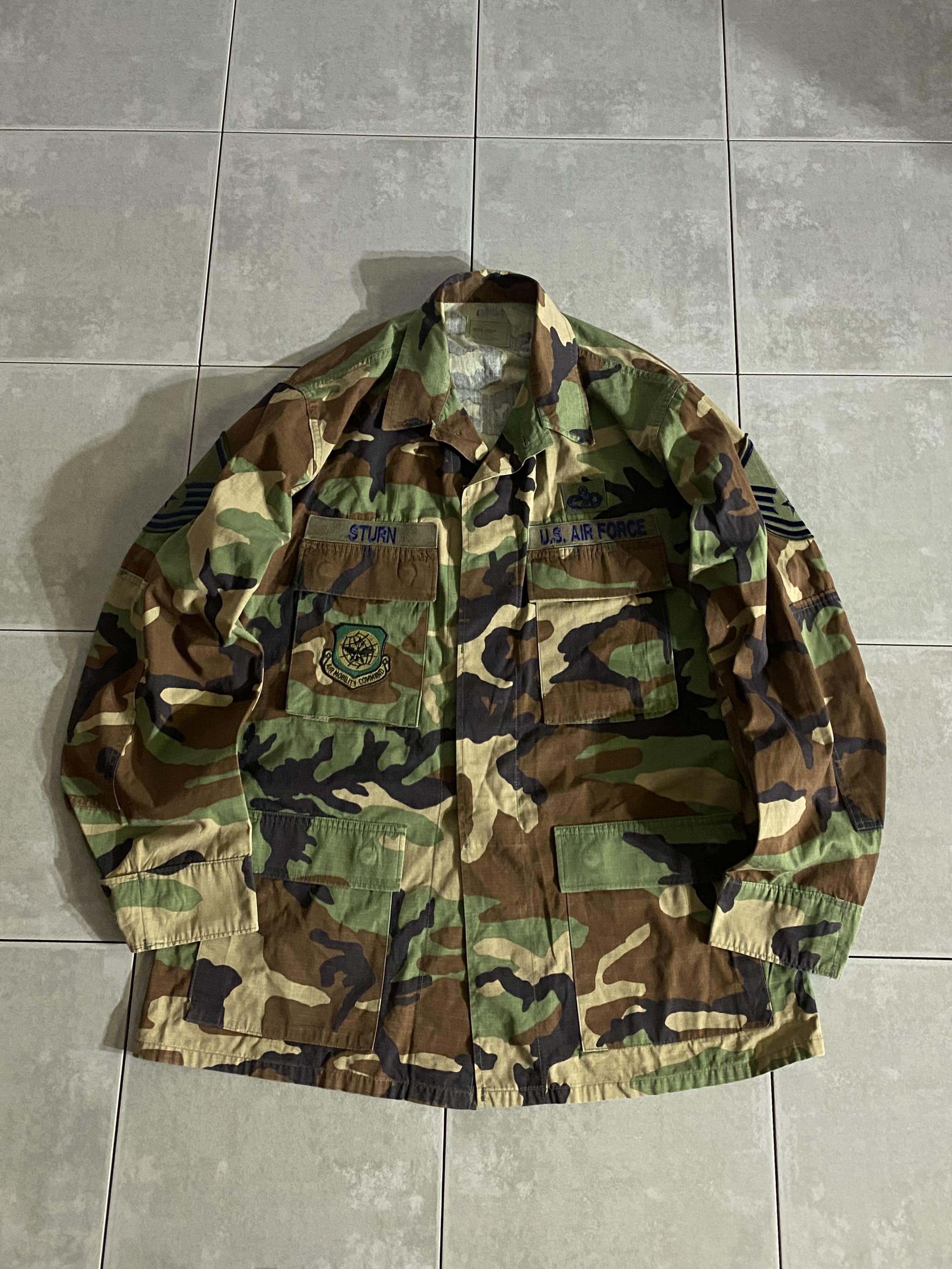 米軍放出品

HOT WEATHER BDU JACKET

【カラー】WOODLAND

【サイズ】M-R
着丈：約78cm　身幅：約60cm　肩幅：約49cm　袖丈：約63cm

【素材】コットン50％　ナイロン50％

リップストップ生地

ウッドランドのHOT WEATHER BDUジャケット。

広範な気候と温度に対応するように開発された
薄手生地のジャケットです。

フロントに4つのポケット、パッチ付き。

かなり状態良いです。

シャツジャケットのような感覚で、
真冬以外の3シーズン着用いただけます。

※画像の程度とは若干異なる場合がございますので予めご了承下さい。
(キズ、へこみ、汚れ、穴あき、ほつれ、文字書入れ(名前、ナンバー)など