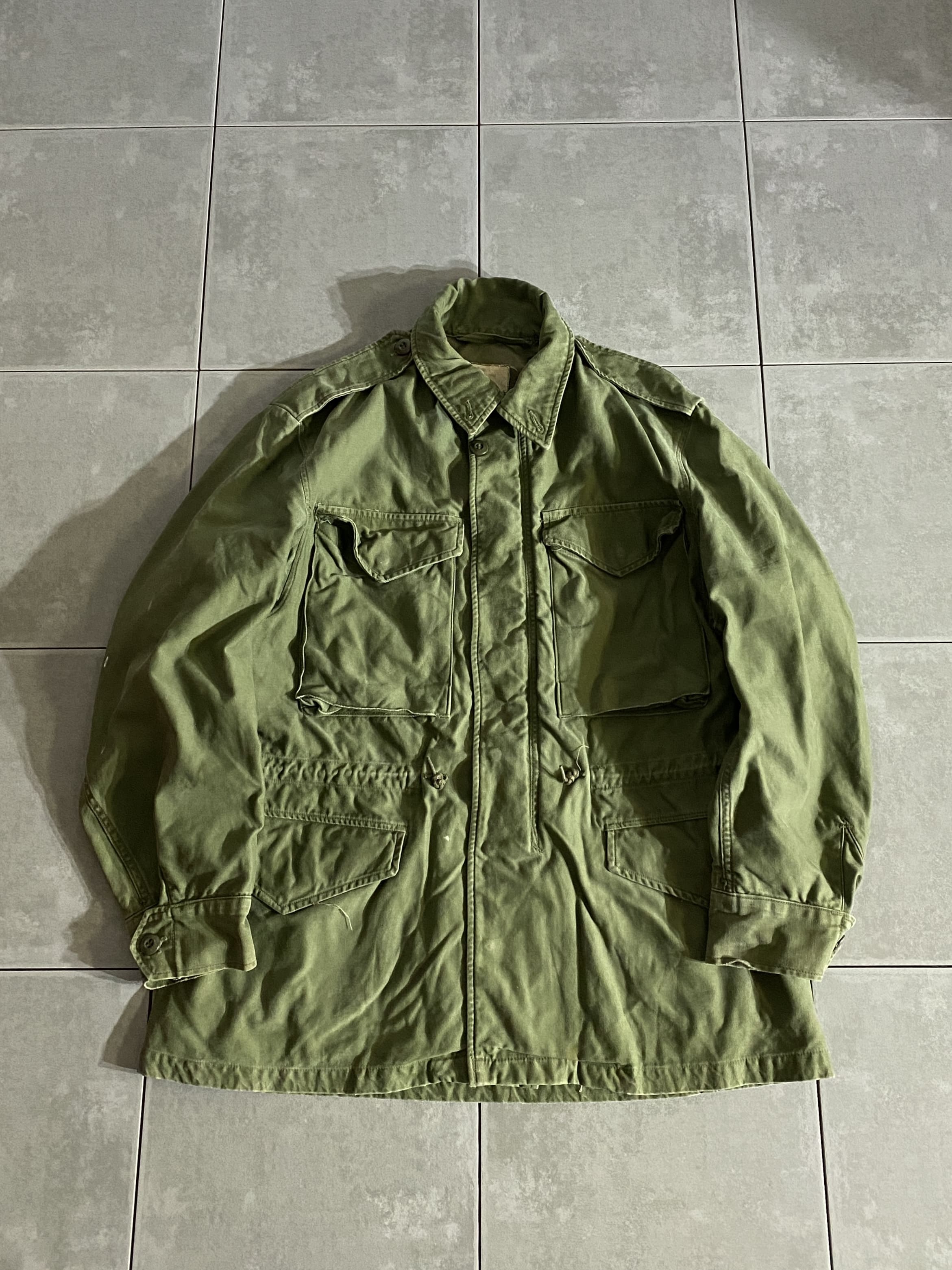 米軍放出品

60s M-51 COTTON WIND RESISTANT SATEEN FIELD JACKET

【カラー】OLIVE GREEN

【サイズ】S-S
着丈：約74cm　身幅：約 56cm　肩幅：約47cm　袖丈：約58cm

【素材】コットン

M-43、M-50フィールドジャケットの意匠を引き継ぎ、
様々な気候でも使用できるように開発された
M-51フィールドジャケット。

現代のファッションにまで影響を与えた、
ミリタリーを語る上で外せない象徴的なアイテムです。

フロントの開閉にはスナップボタンとジッパーが採用され、
フィット感を高めるウエストのドローコードは
外側に備わっています。

なかなか見つからなくなってきた希少なアイテム、
コレクションとしても持っておきたい一着です。

※画像の程度とは若干異なる場合がございますので予めご了承下さい。
(キズ、へこみ、汚れ、穴あき、ほつれ、文字書入れ(名前、ナンバー)など

