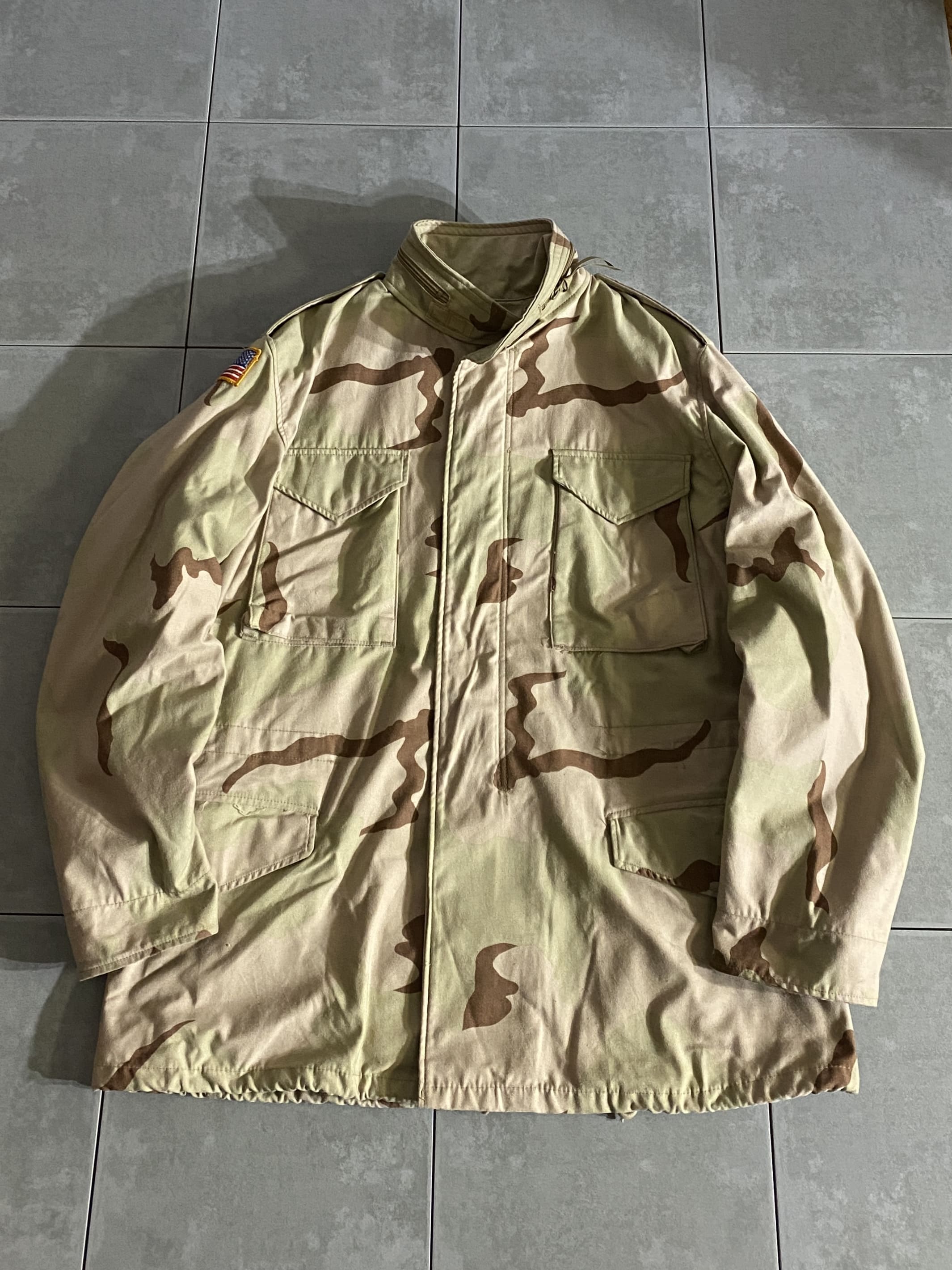 米軍放出品

M-65 Field Jacket 3C Desert camo

【カラー】3C

【サイズ】L-L
着丈：約84cm　身幅：約66cm　肩幅：約55cm　袖丈：約66lcm

【素材】コットン50％　ナイロン50％

軍が開発したミリタリーアイテムの中で最高傑作ともいえる
M-65 Field Jacket。

ミリタリーを語る上で外せないアイテムです。

1989年頃より限定的な支給が開始された
デザート・パターン。

デザート・パターンは日中50度を越す砂漠地帯であっても
寒暖の激しさから夜間、作戦地域、季節によっては、
防寒目的のField Jacket は必需品です。

※画像の程度とは若干異なる場合がございますので予めご了承下さい。
(キズ、へこみ、汚れ、穴あき、ほつれ、文字書入れ(名前、ナンバー)など
