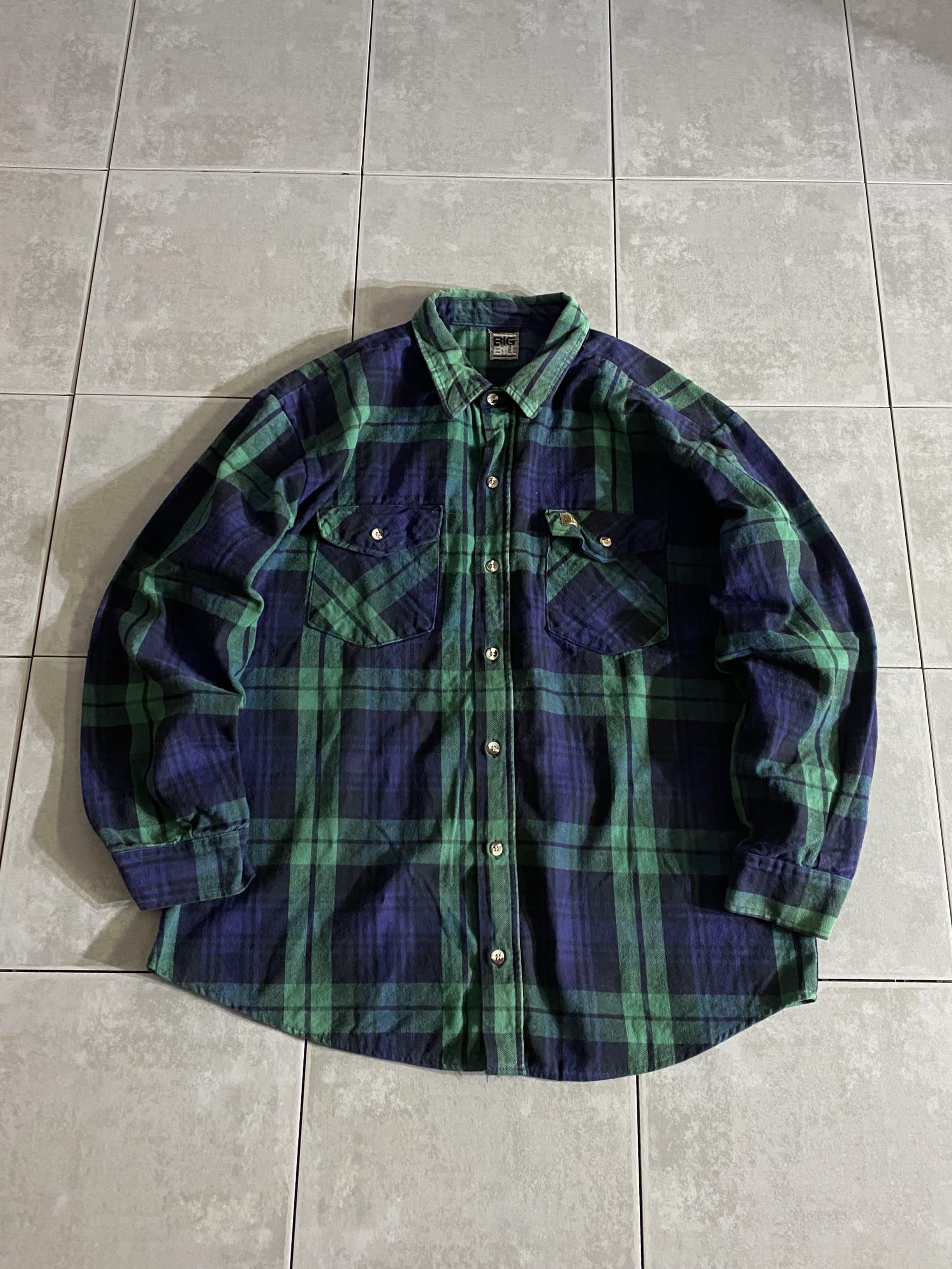 BIG BILL

【BIG BILL】Flannel Heavy Weight Shirt

【カラー】グリーン

【サイズ】不明
着丈：約75cm　身幅：約60cm　肩幅：約55cm　袖丈：約58cm

【素材】コットン100％

ヘビーなコットンネルを使ったBIG BILLのワークシャツ。

ネーム入りのボタンや胸のレザーパッチは
BIG BILLならではのこだわり。

ライトアウターとしても使える程のヘビーオンスなネルで、
着れば着るほど味が出る1着です。

※画像の程度とは若干異なる場合がございますので予めご了承下さい。
(キズ、へこみ、汚れ、穴あき、ほつれ、文字書入れ(名前、ナンバー)など