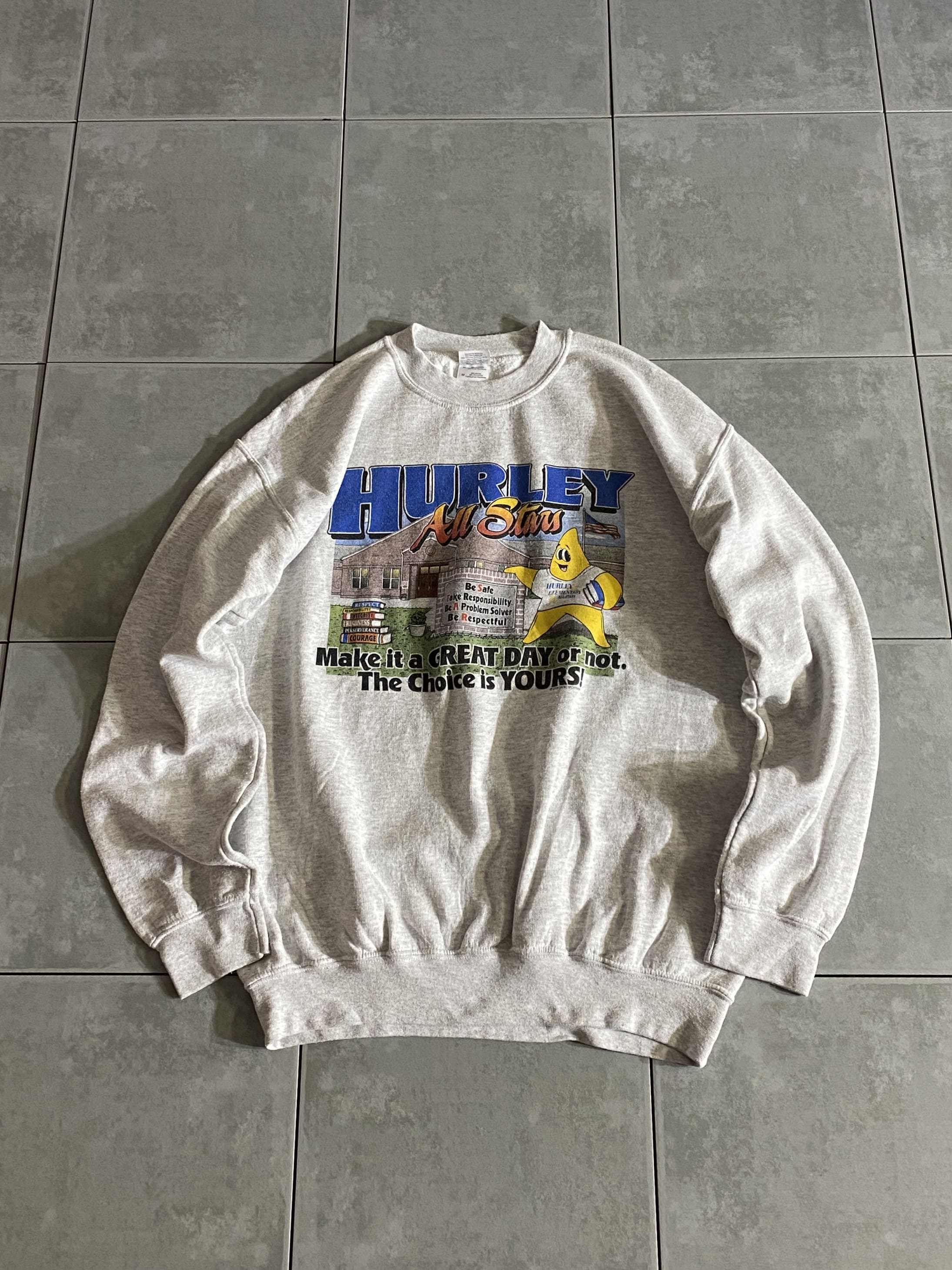 GILDAN

【GILDAN】HURLEY ALL STARS Sweatshirt

【カラー】グレー

【サイズ】M
着丈：約67cm　身幅：約55cm　肩幅：約55cm　袖丈：約56cm

【素材】コットン50％　ポリエステル50％

GILDANボディーのスウェットシャツ。

存在感のある可愛らしいポップなデザインに、
使いやすいグレーボディー。

目立ったダメージもなく、男女問わず楽しんでお使いいただけます。

※画像の程度とは若干異なる場合がございますので予めご了承下さい。
(キズ、へこみ、汚れ、穴あき、ほつれ、文字書入れ(名前、ナンバー)など



