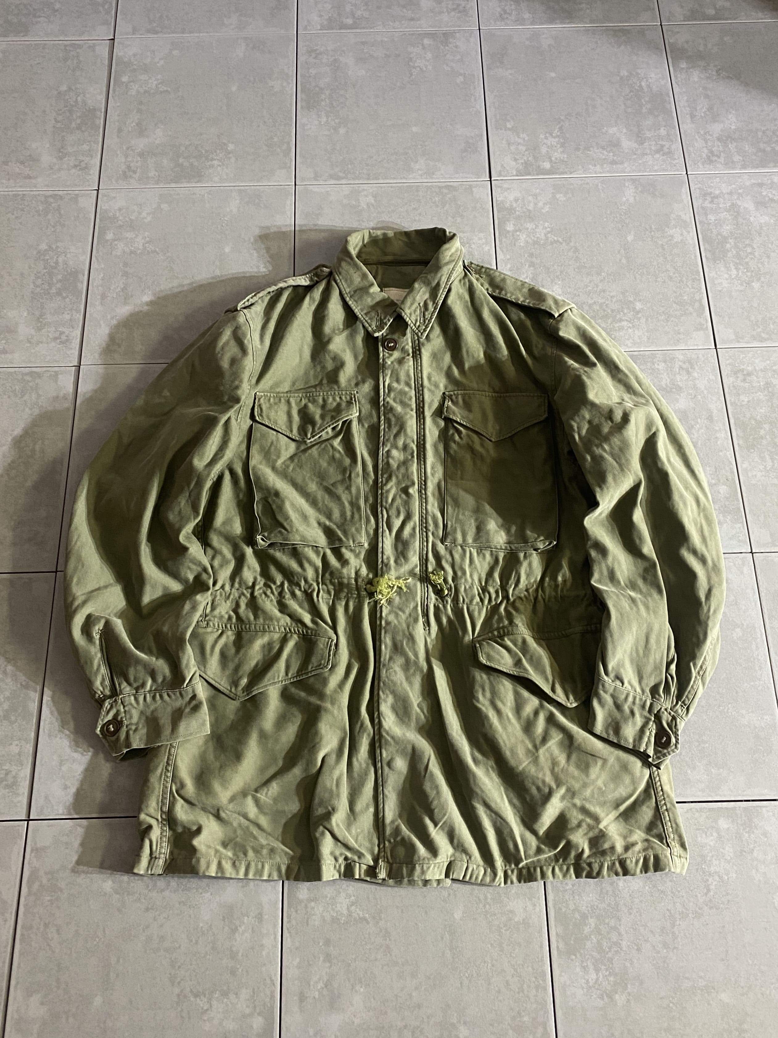 米軍放出品

M-51 Field Jacket

【カラー】OLIVE GREEN

【サイズ】M-L
着丈：約81cm　身幅：約57cm　肩幅：約52cm　袖丈：約66cm

【素材】コットン

M-43、M-50フィールドジャケットの意匠を引き継ぎ、
様々な気候でも使用できるように開発された
M-51フィールドジャケット。

現代のファッションにまで影響を与えた、
ミリタリーを語る上で外せない象徴的なアイテムです。

フロントの開閉にはスナップボタンとジッパーが採用され、
フィット感を高めるウエストのドローコードは
外側に備わっています。

なかなか見つからなくなってきた希少なアイテム、
コレクションとしても持っておきたい一着です。

※画像の程度とは若干異なる場合がございますので予めご了承下さい。
(キズ、へこみ、汚れ、穴あき、ほつれ、文字書入れ(名前、ナンバー)など

