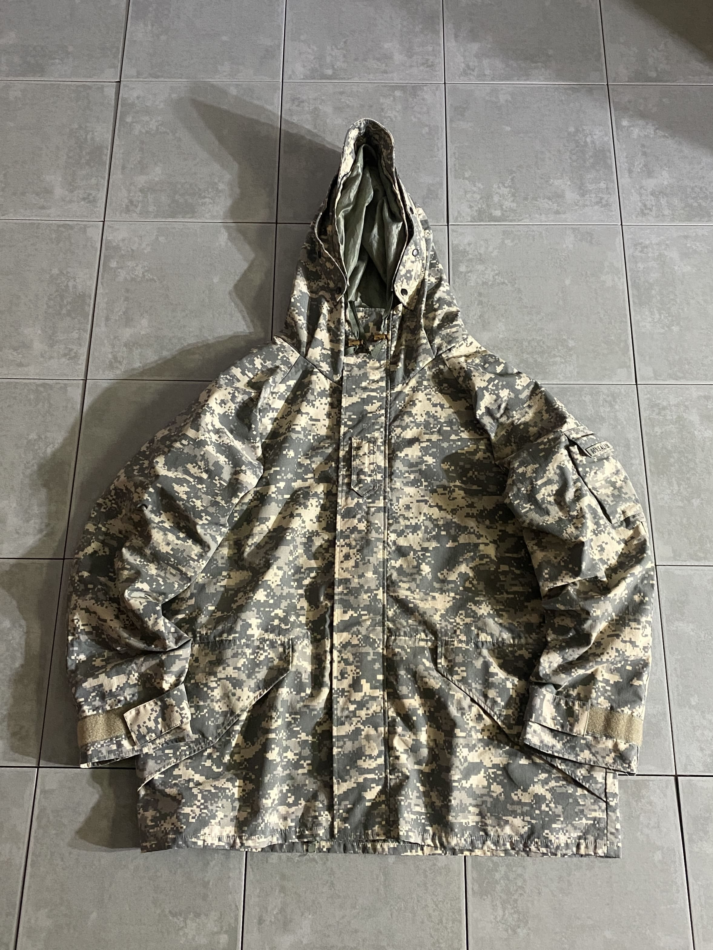 TRU-SPEC

【TRU-SPEC】ECWCS H2O Proof Parka

【カラー】ACU

【サイズ】XL-R
着丈：約76cm　身幅：約69cm　裄丈：約92cm　

【素材】ナイロン100％

TRU-SPECのECWCSパーカー。

Gen1 ECWCSパーカーのデザイン。

天候に関係なくドライで快適な状態を保つために
防風、耐水、発汗蒸気透過性を持った三層コーティング構造の
H2O PROOFを使用しています。

春秋のライトアウターやストリートスタイルにはもちろん、
ウィンタースポーツからアウトドアユース向けにも
活躍してくれる一着。

夏以外の3シーズンお使い頂ける万能アイテムです。

※画像の程度とは若干異なる場合がございますので予めご了承下さい。
(キズ、へこみ、汚れ、穴あき、ほつれ、文字書入れ(名前、ナンバー)など