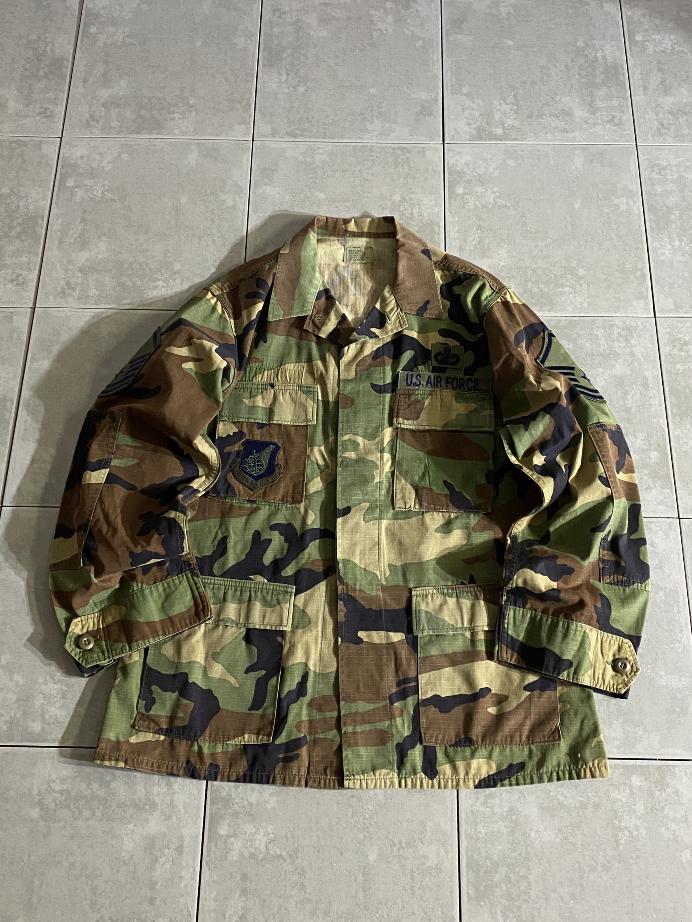 米軍放出品

HOT WEATHER BDU JACKET

【カラー】WOODLAND

【サイズ】M-R
着丈：約74cm　身幅：約60cm　肩幅：約47cm　袖丈：約60cm

【素材】コットン50％　ナイロン50％

リップストップ生地

ウッドランドのHOT WEATHER BDUジャケット。

広範な気候と温度に対応するように開発された
薄手生地のジャケットです。

フロントに4つのポケットがございます。

シャツジャケットのような感覚で、
真冬以外の3シーズン着用いただけます。

※画像の程度とは若干異なる場合がございますので予めご了承下さい。
(キズ、へこみ、汚れ、穴あき、ほつれ、文字書入れ(名前、ナンバー)など