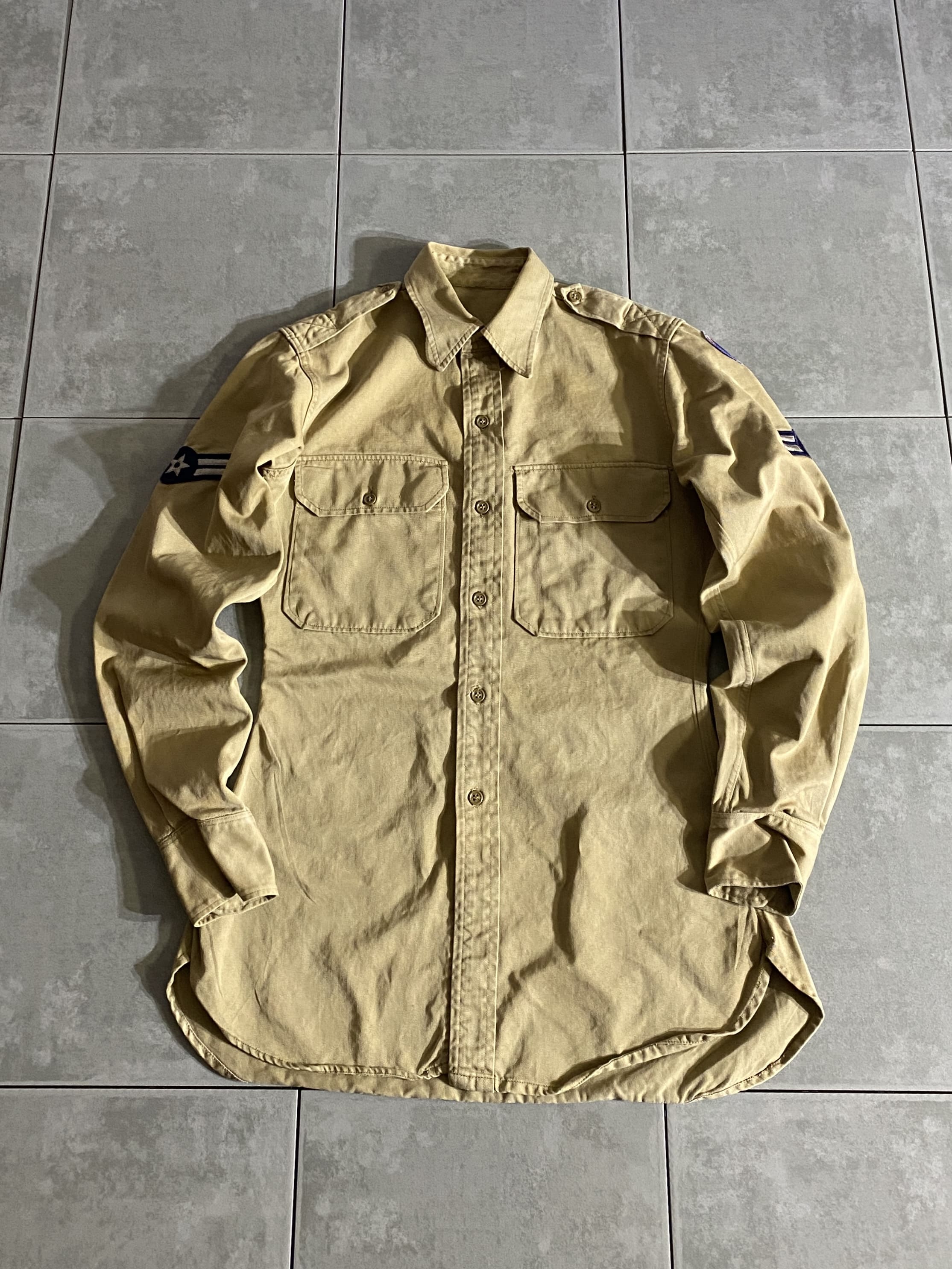 L/S 

Officer shirt

【カラー】カーキ

【サイズ】不明(恐らく14 1/2×33)
着丈：約75cm　身幅：約50cm　肩幅：約41cm　袖丈：約61cm

【素材】コットン

着込むほどに風合いの良い経年変化を楽しめる
パッチ付きのオフィサーシャツ。

チノ素材のような生地感で、タイトめでキレイなシルエットです。

シンプルなデザインでカジュアルから少しきれいめなスタイルまで
幅広く活躍するアイテムです。

※首元に薄く印字見えますが、ほぼ消えております。

※左袖、シミがございます。

※画像の程度とは若干異なる場合がございますので予めご了承下さい。
(キズ、へこみ、汚れ、穴あき、ほつれ、文字書入れ(名前、ナンバー)など

