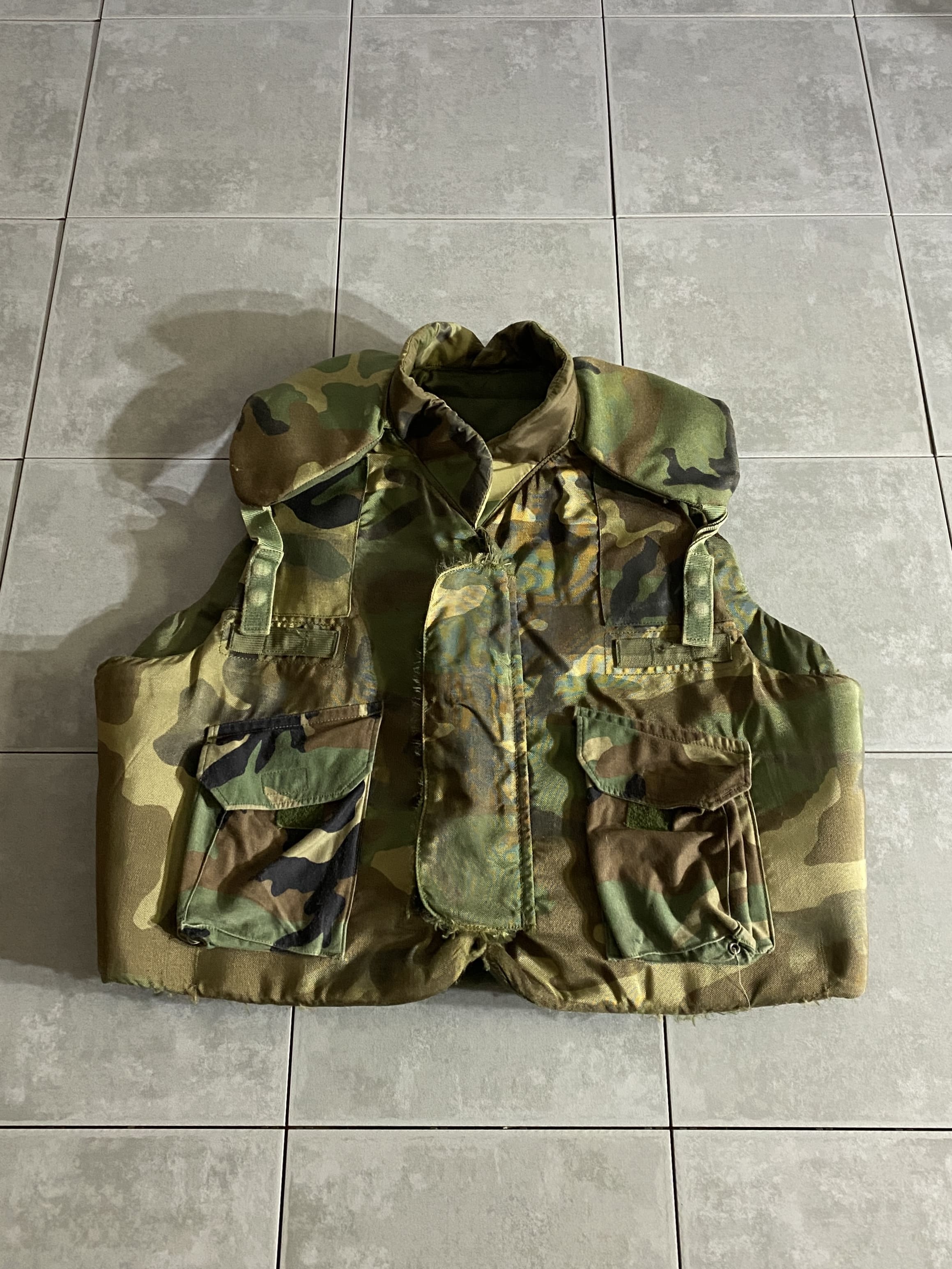 米軍放出品

Body Armor Fragmentation Protective Vest

【カラー】WOODLAND

【サイズ】XL
着丈：約60cm　身幅：約64cm　肩幅：約48cm

【重量】約5kg

米軍実物のボディーアーマーベスト。

弾を防ぐものではなく、爆発した破片などから身を守るために
着用されていたベスト。

重量は約5kg程あり、しっかり重いです。

全体的に使用感ございますが、着用に問題はございません。

最近ではなかなか見つからない珍しいアイテムかと思いますので
コレクションなどにオススメです。

※画像の程度とは若干異なる場合がございますので予めご了承下さい。
(キズ、へこみ、汚れ、穴あき、ほつれ、文字書入れ(名前、ナンバー)など